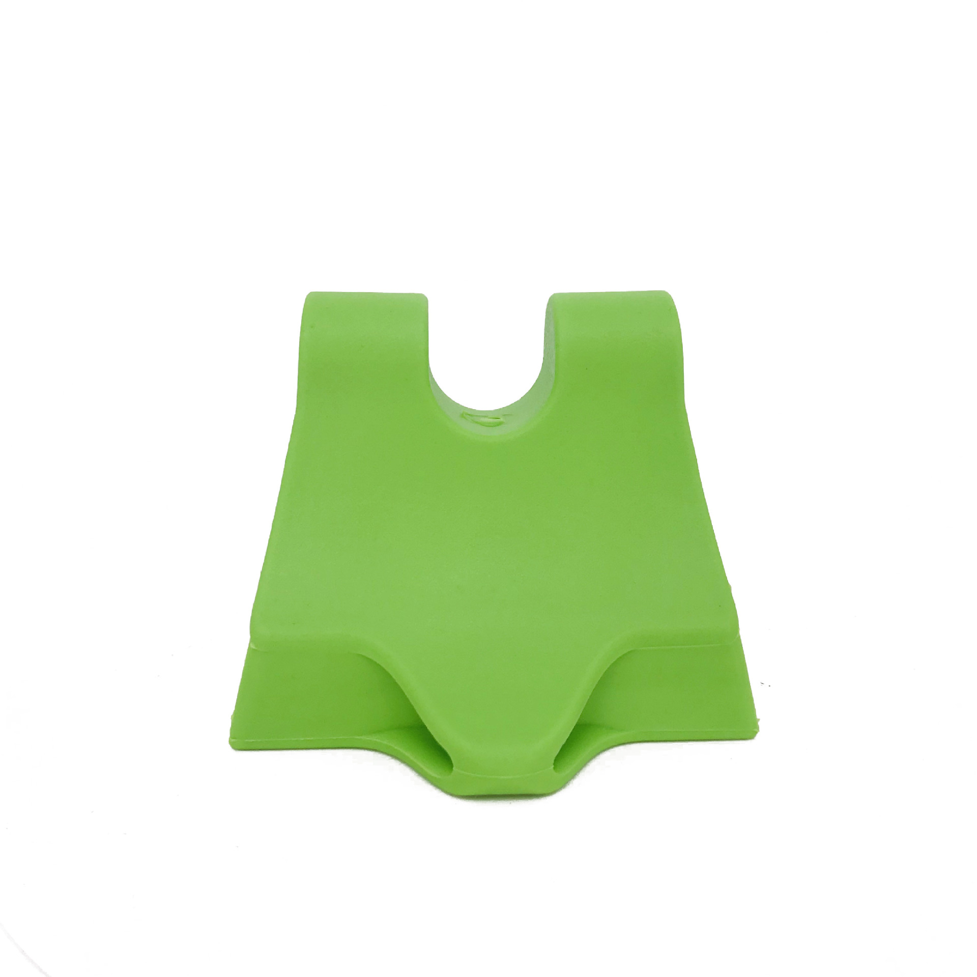 Ein leuchtend grüner Yoga-Block aus Silikon mit einzigartiger Form auf weißem Grund.