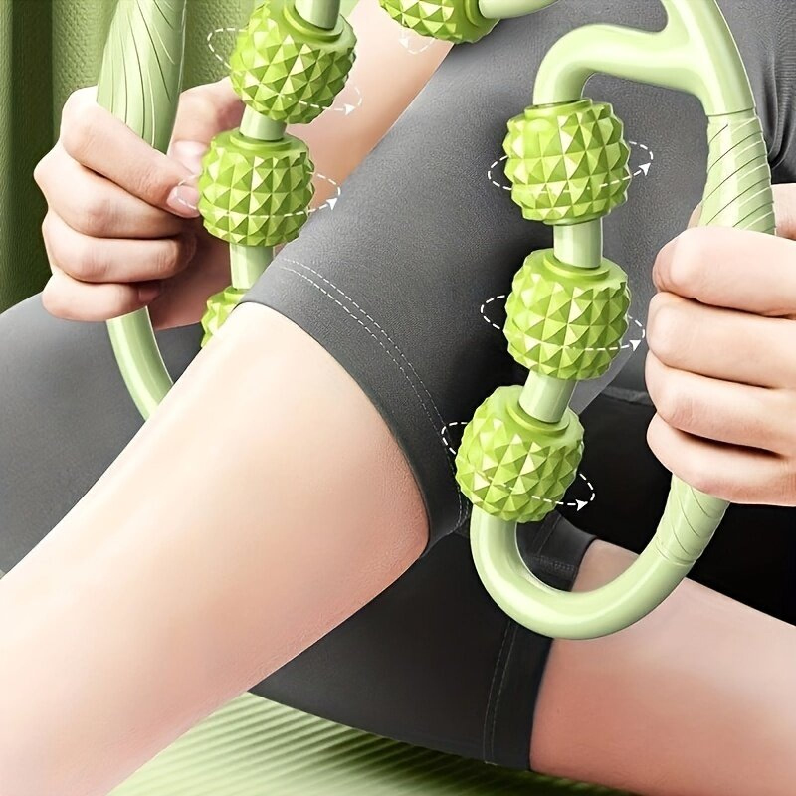 Eine Person massiert ihr Bein mit einem grünen Handroller und trägt graue Shorts.