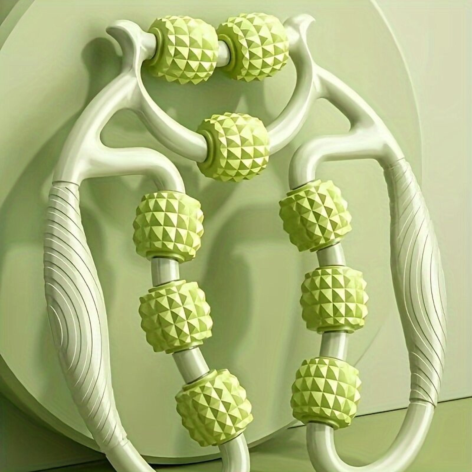 Ein weiß-grüner Massage-Handroller mit genoppten Rollen.