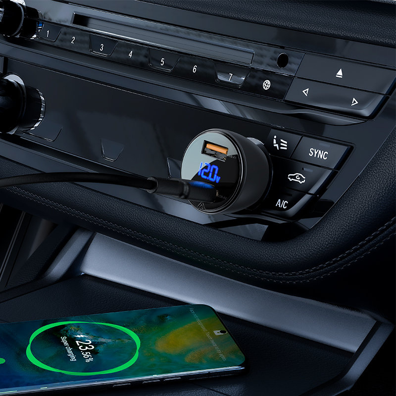 Un caricatore per auto con display digitale e cavo collegato è inserito nella presa da 12V di un'auto.