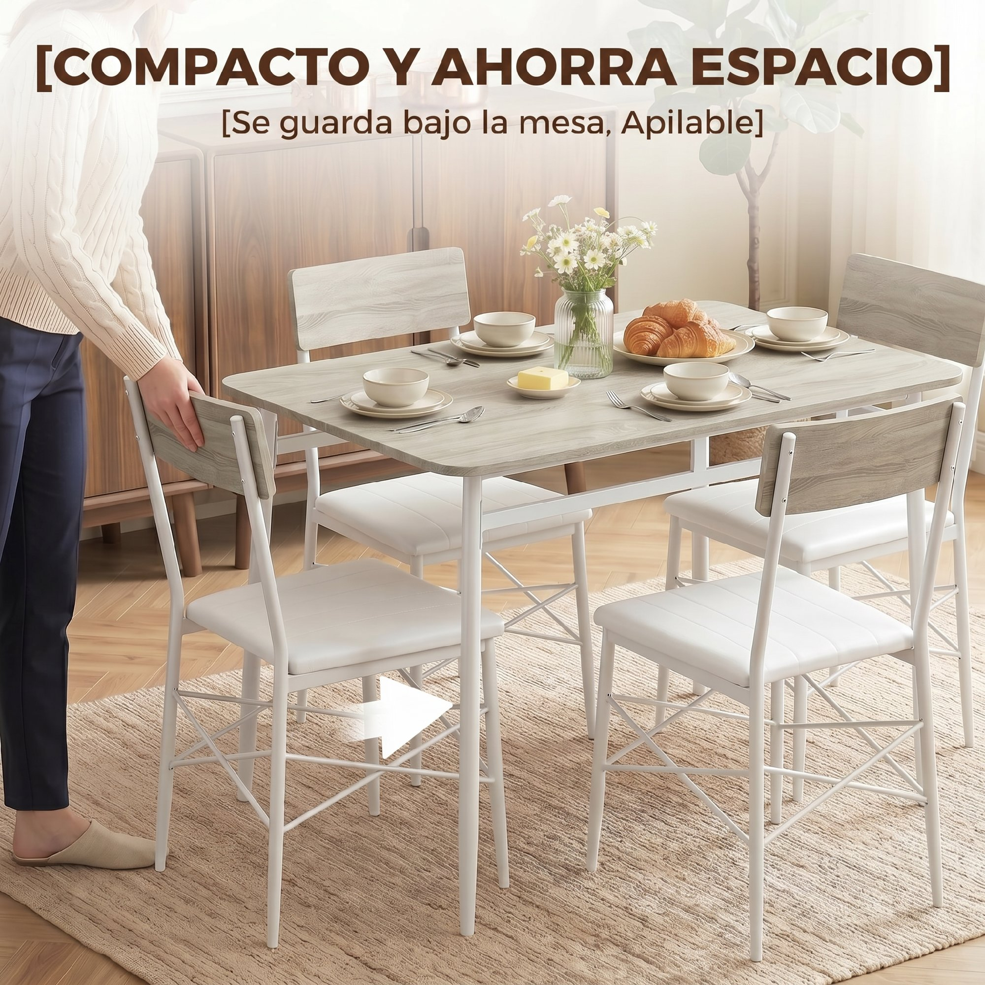 Una persona empuja un comedor compacto con sillas blancas y vajilla en una habitación luminosa.