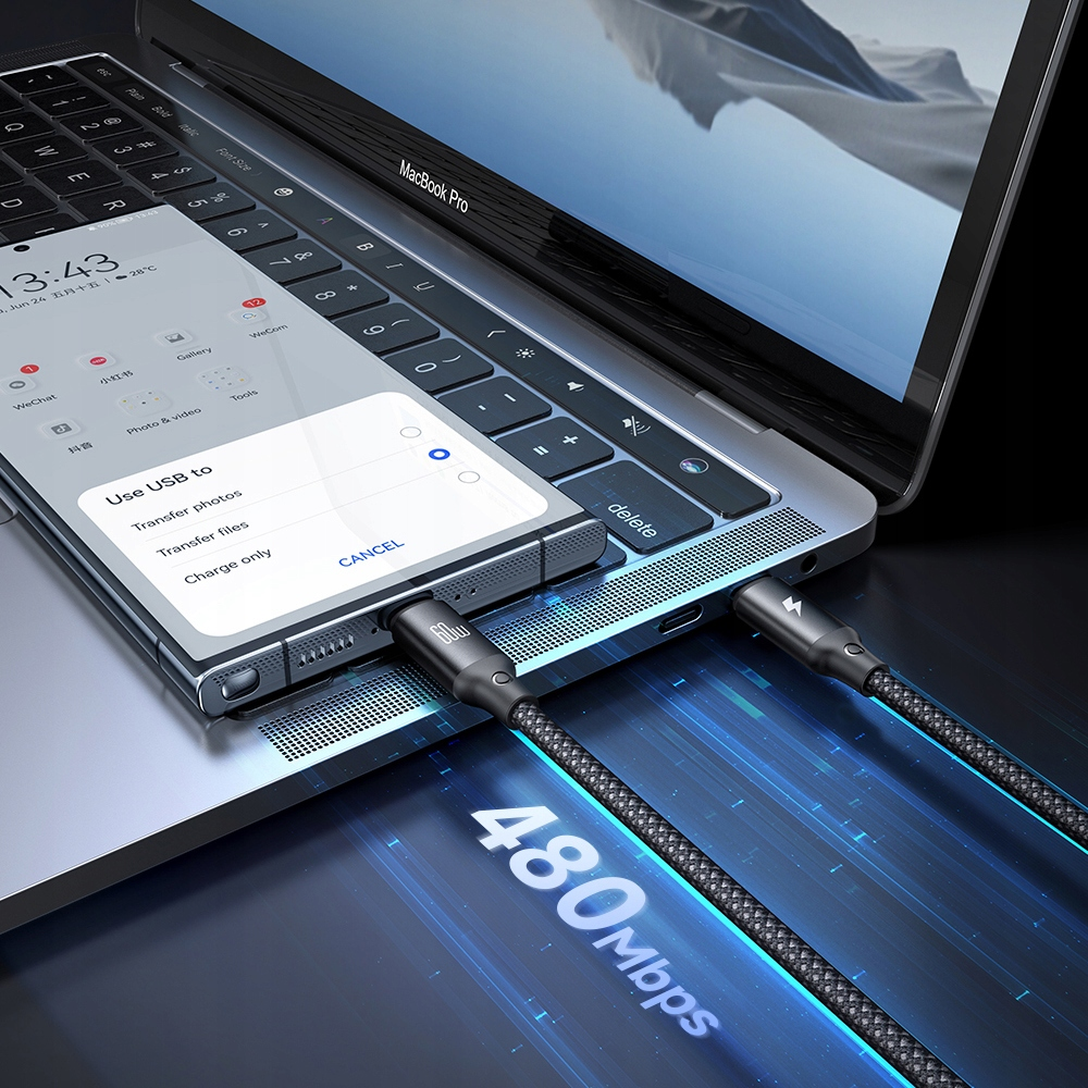 Uno smartphone collegato a un laptop con cavi intrecciati e un menu di trasferimento USB sullo schermo.
