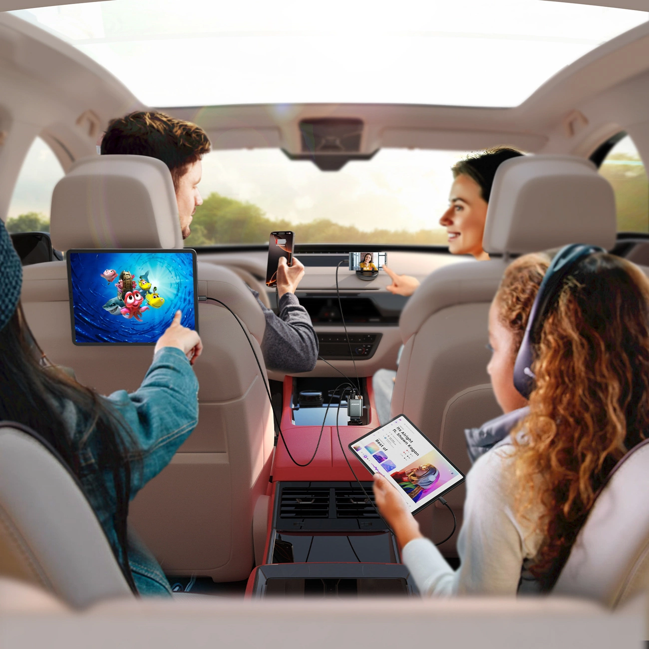 Famiglia in auto, i bambini guardano tablet e persone caricano smartphone con un caricatore.