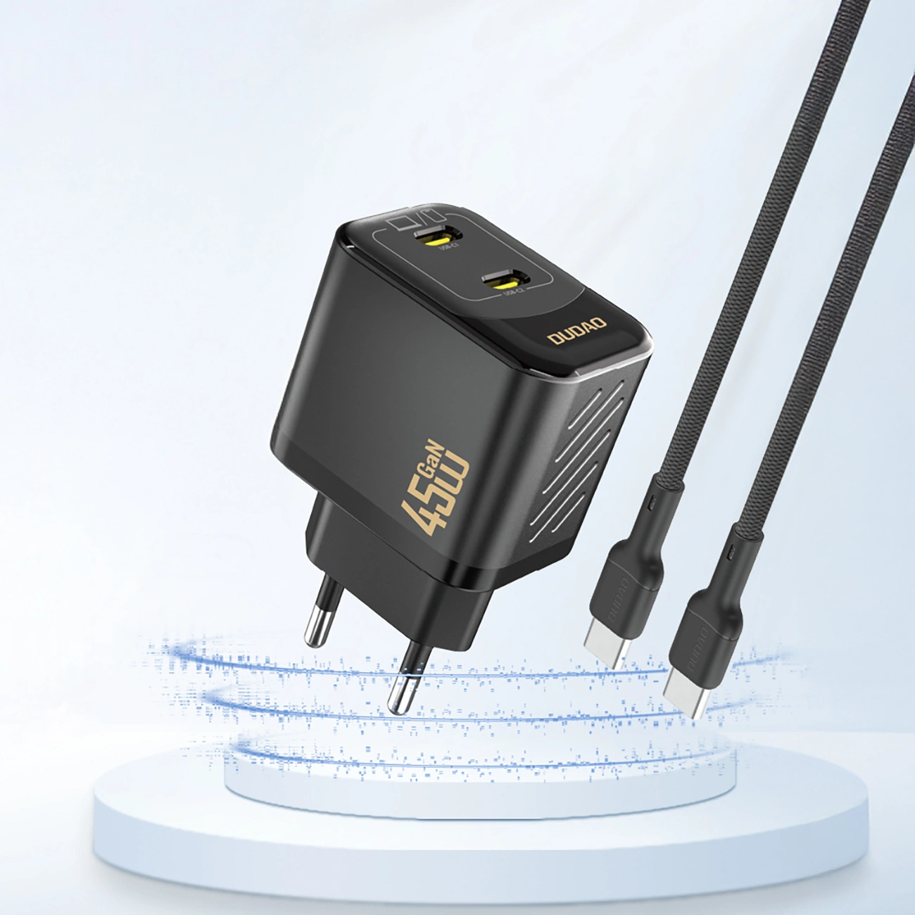 Un caricabatterie da muro GaN nero da 45 W con due porte USB-C e due cavi intrecciati neri su un podio.