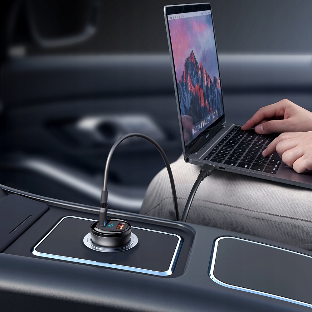 Un computer portatile viene caricato in auto tramite un caricatore USB nella console.