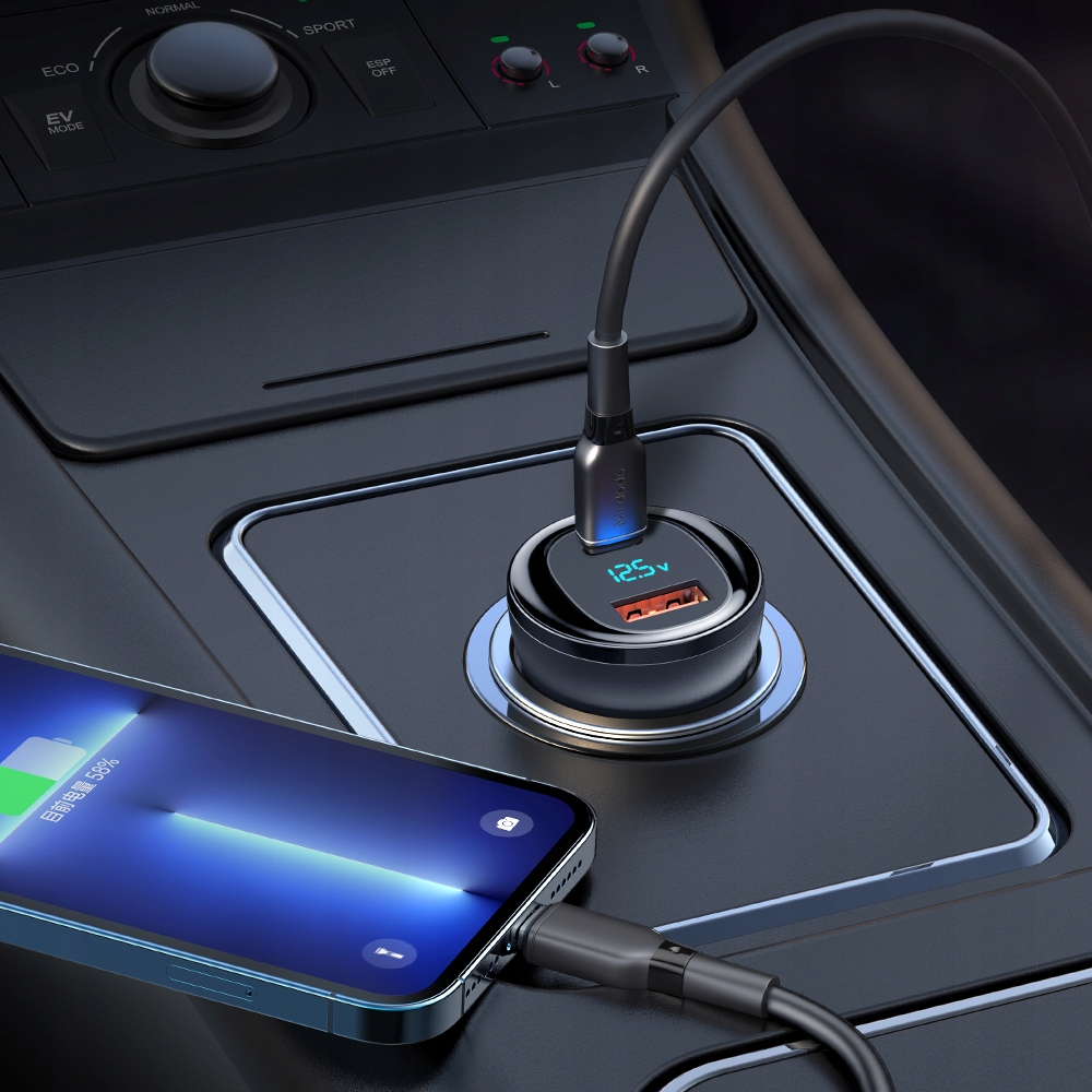 Un caricabatterie per auto nero con display digitale è inserito nella presa, collegato a uno smartphone.