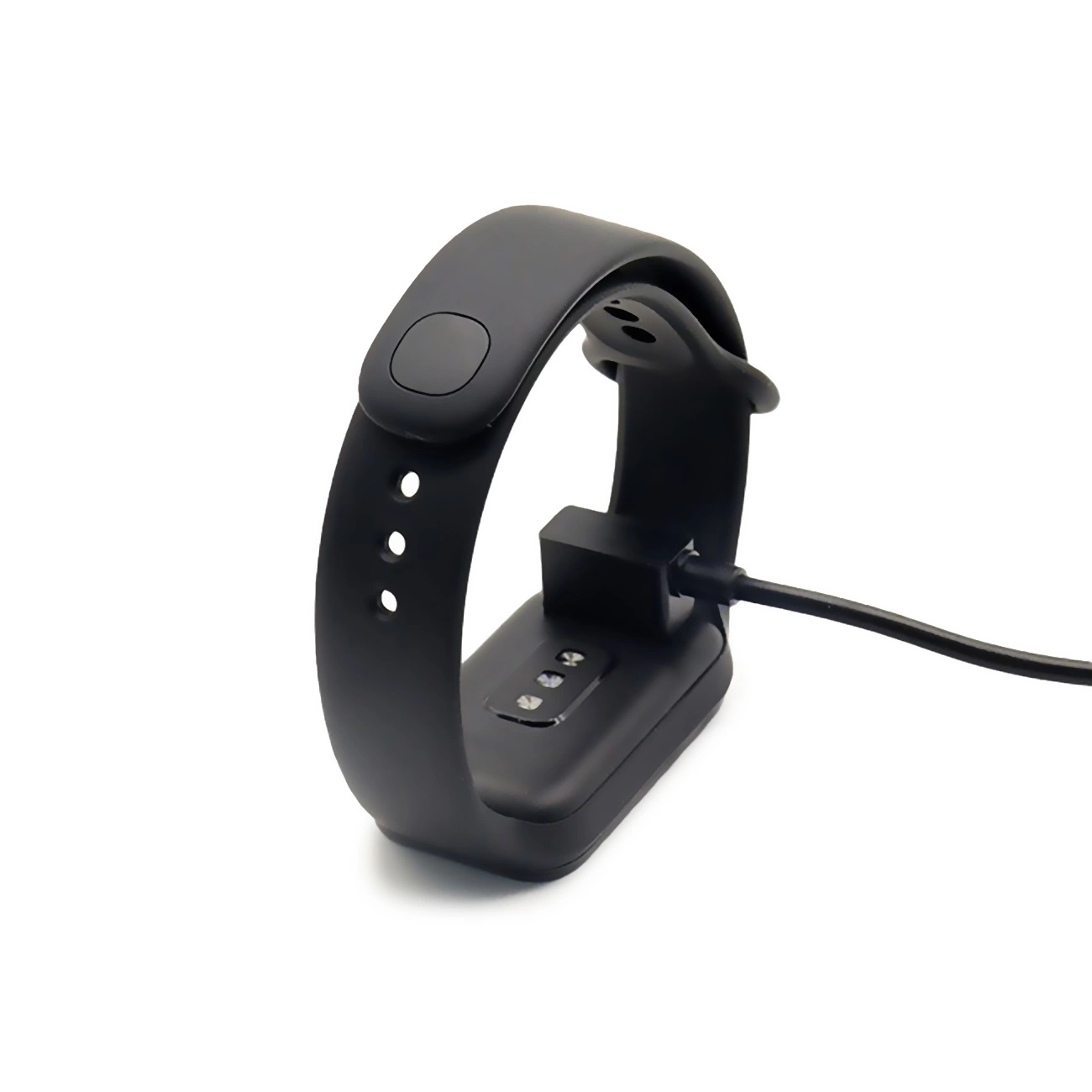 Un fitness tracker nero si sta ricaricando su una superficie bianca con un cavo collegato.