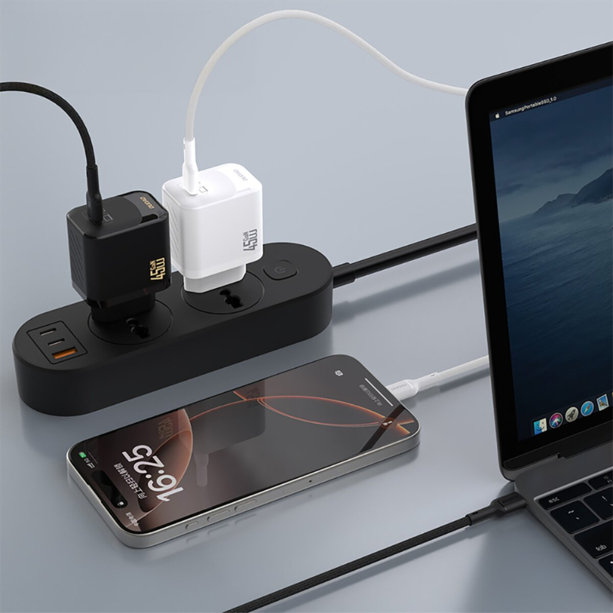 Una ciabatta nera carica uno smartphone e un computer portatile usando caricatori bianchi e neri.