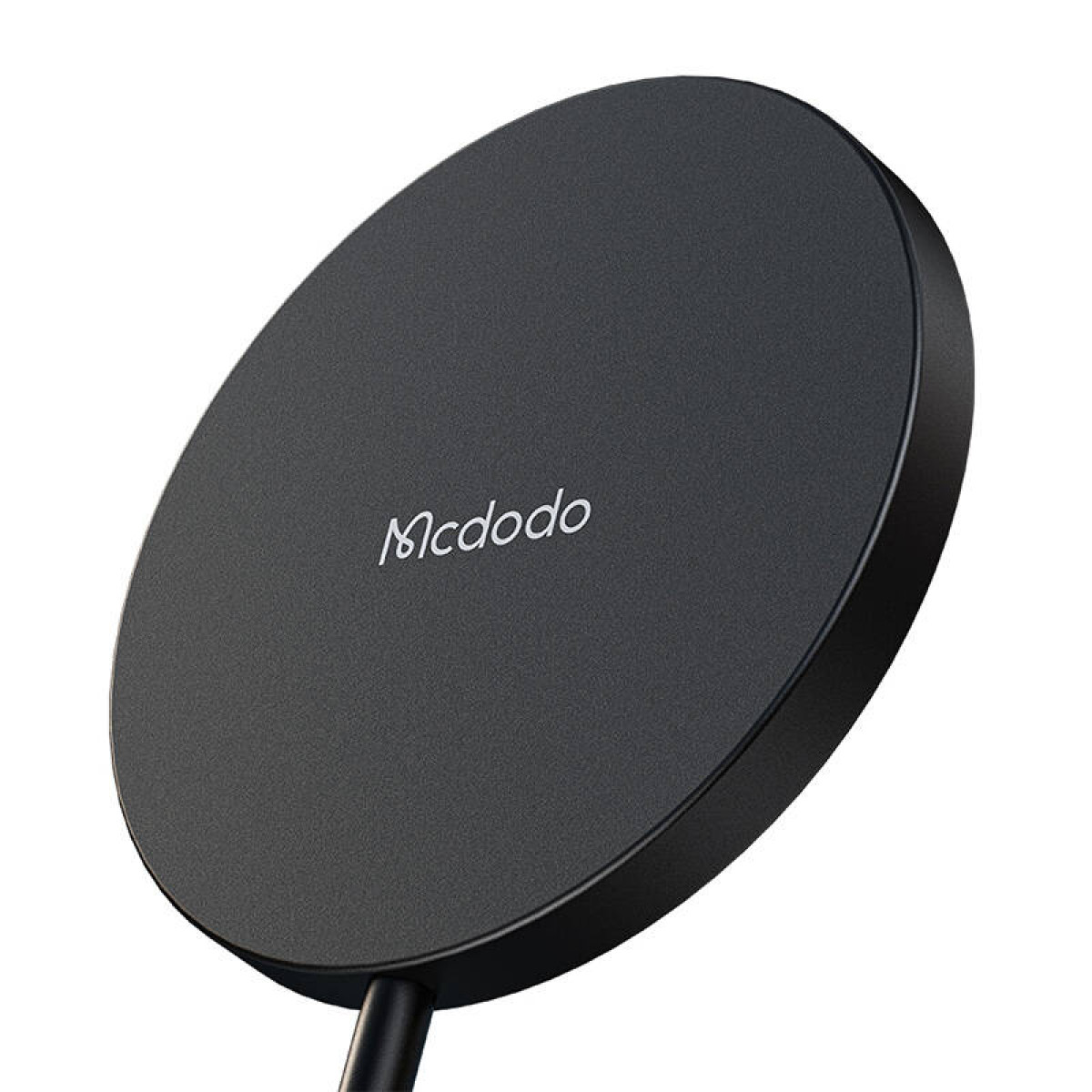 Caricabatterie wireless Mcdodo nero e rotondo con cavo collegato su sfondo bianco.