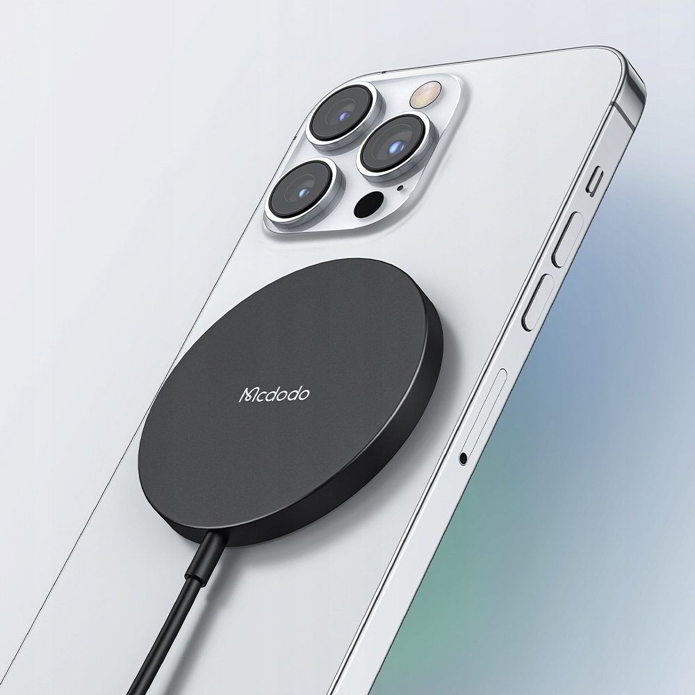 Un caricatore wireless Mcdodo circolare nero è attaccato magneticamente al retro di uno smartphone bianco.