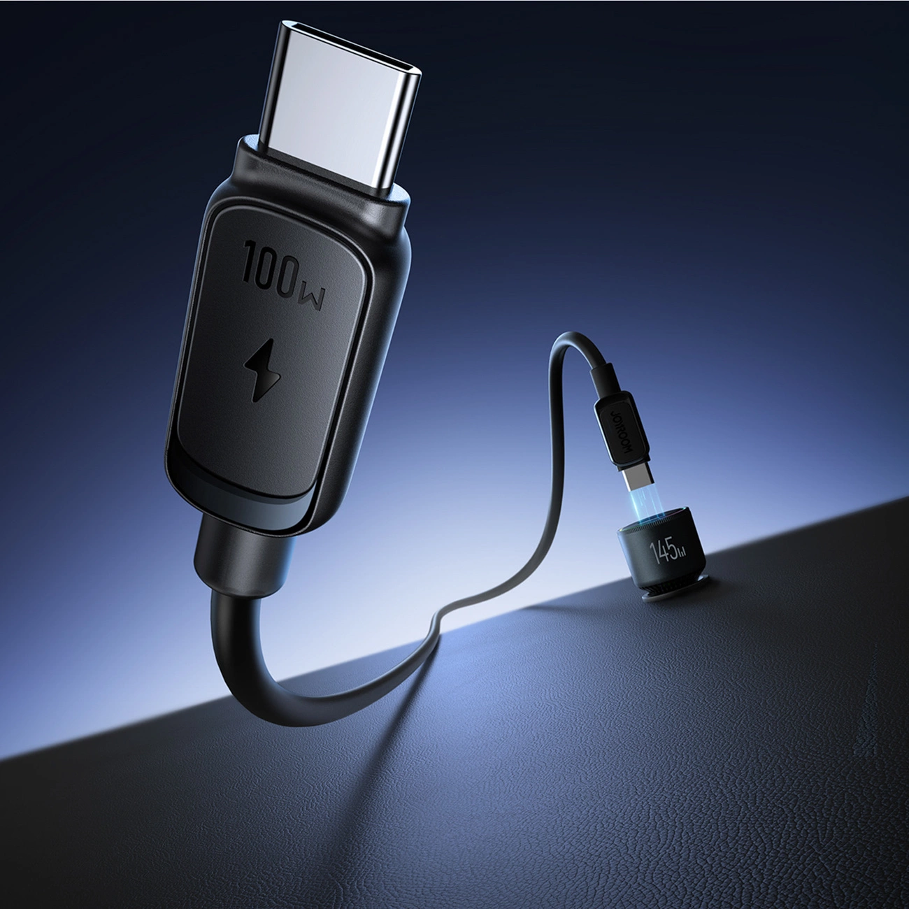 Un cavo di ricarica nero da 100W con connettore USB-C, su una superficie scura.