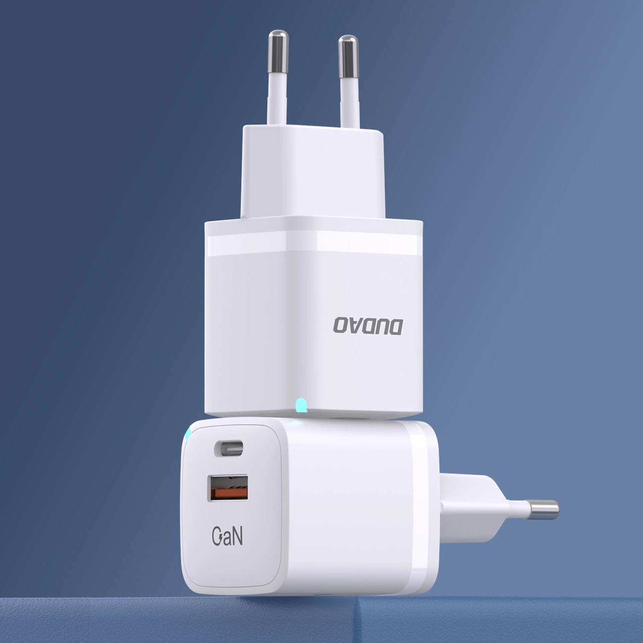 Due caricabatterie USB GaN bianchi impilati su sfondo blu.