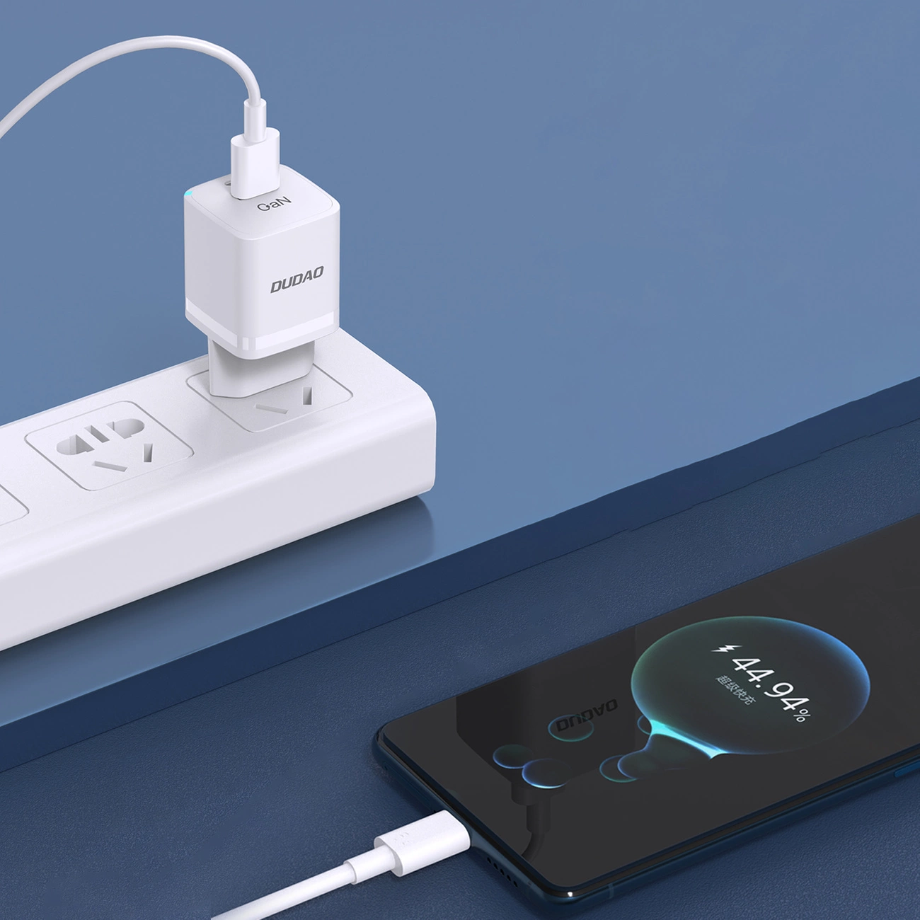 Un caricabatterie USB bianco inserito in una ciabatta e uno smartphone collegato che mostra una schermata di ricarica.