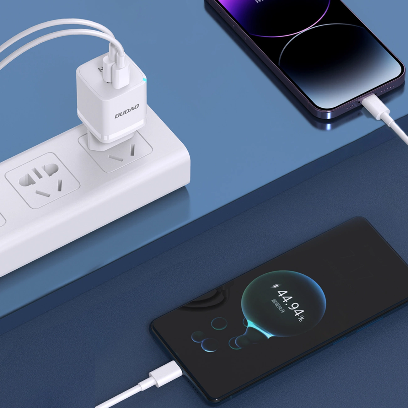 Un caricabatterie USB bianco collegato a una ciabatta carica due smartphone.