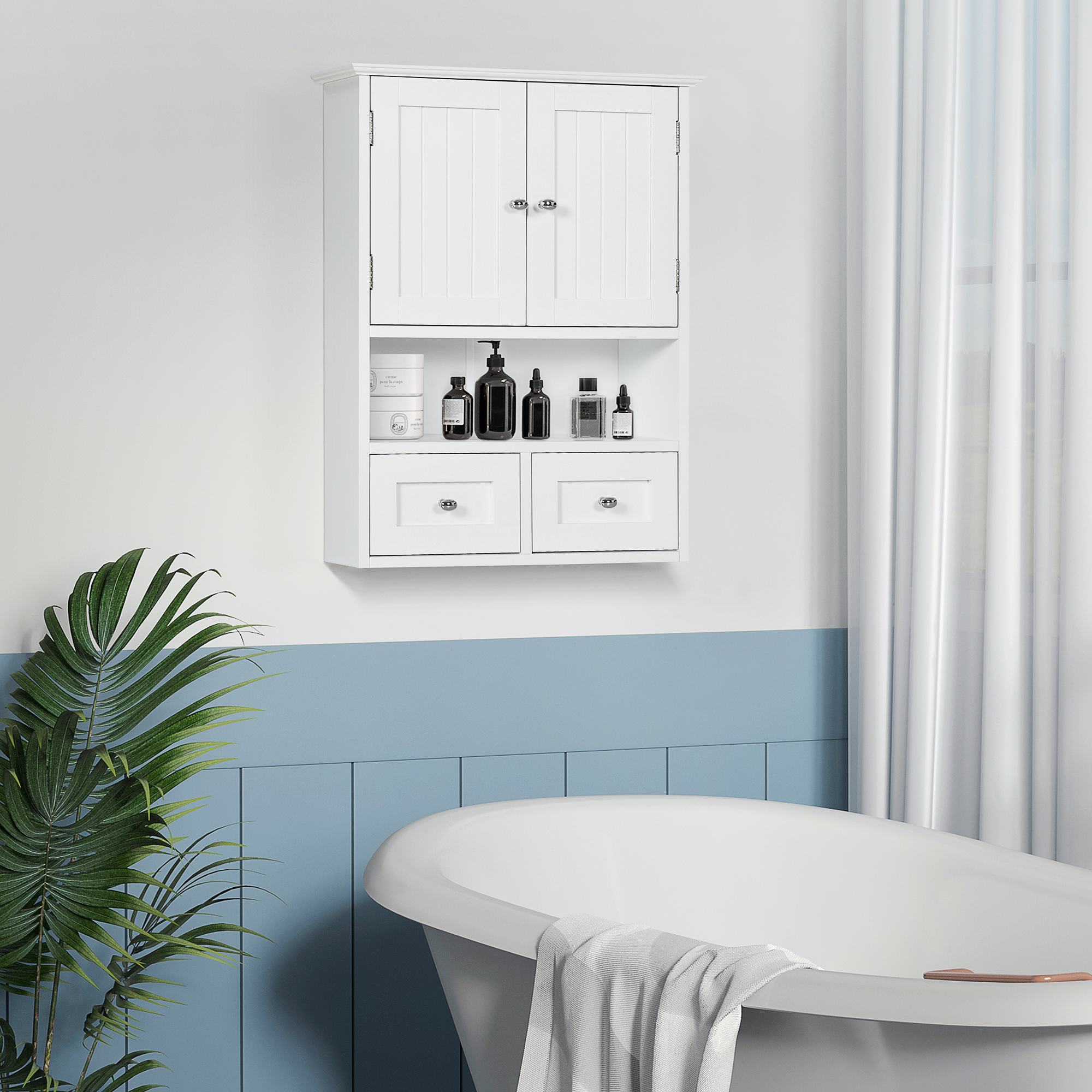 Un armario de pared blanco cuelga sobre una bañera en una habitación con revestimiento azul y una planta verde.