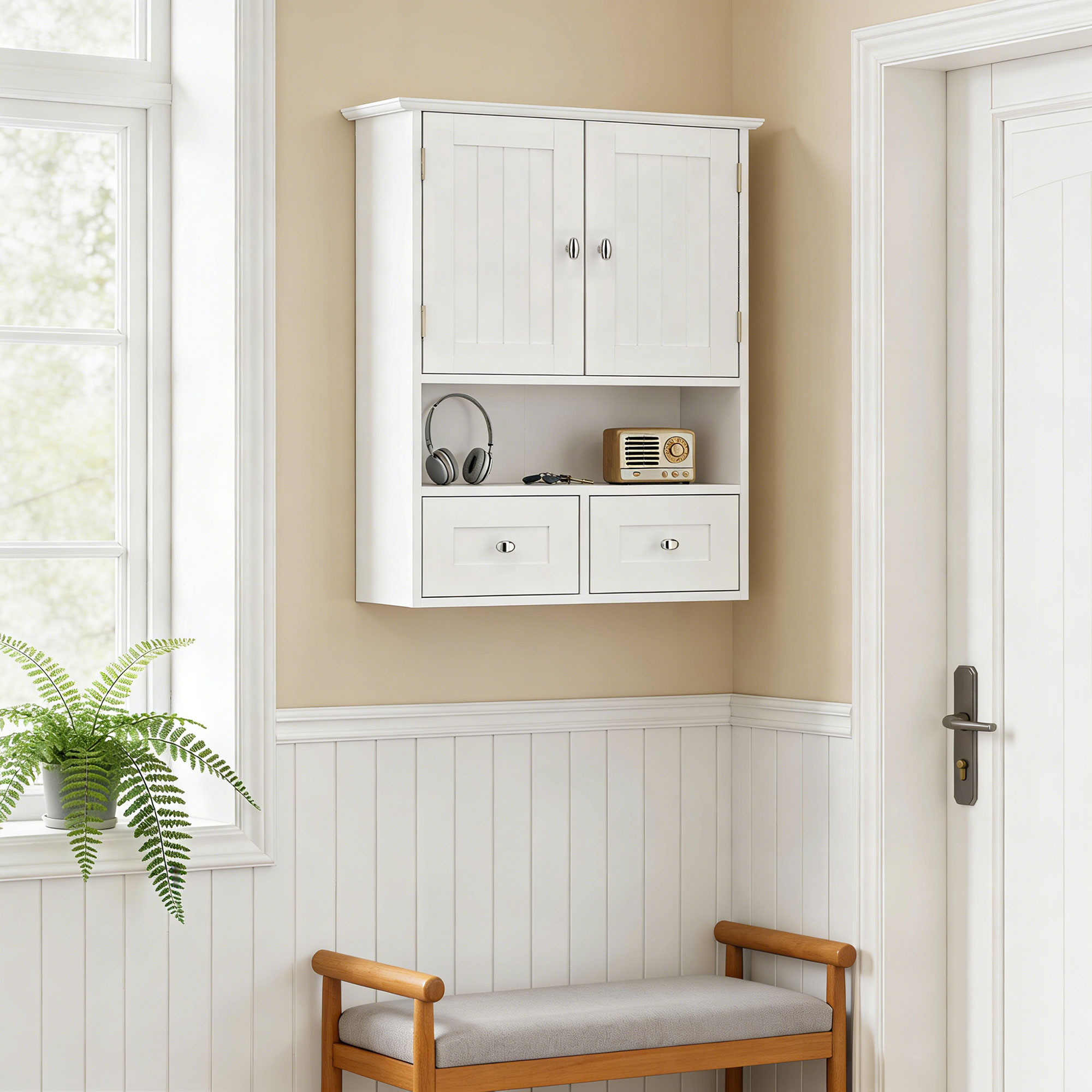 Un armario de pared blanco con dos puertas, un estante abierto y dos cajones cuelga en una pared beige y blanca.
