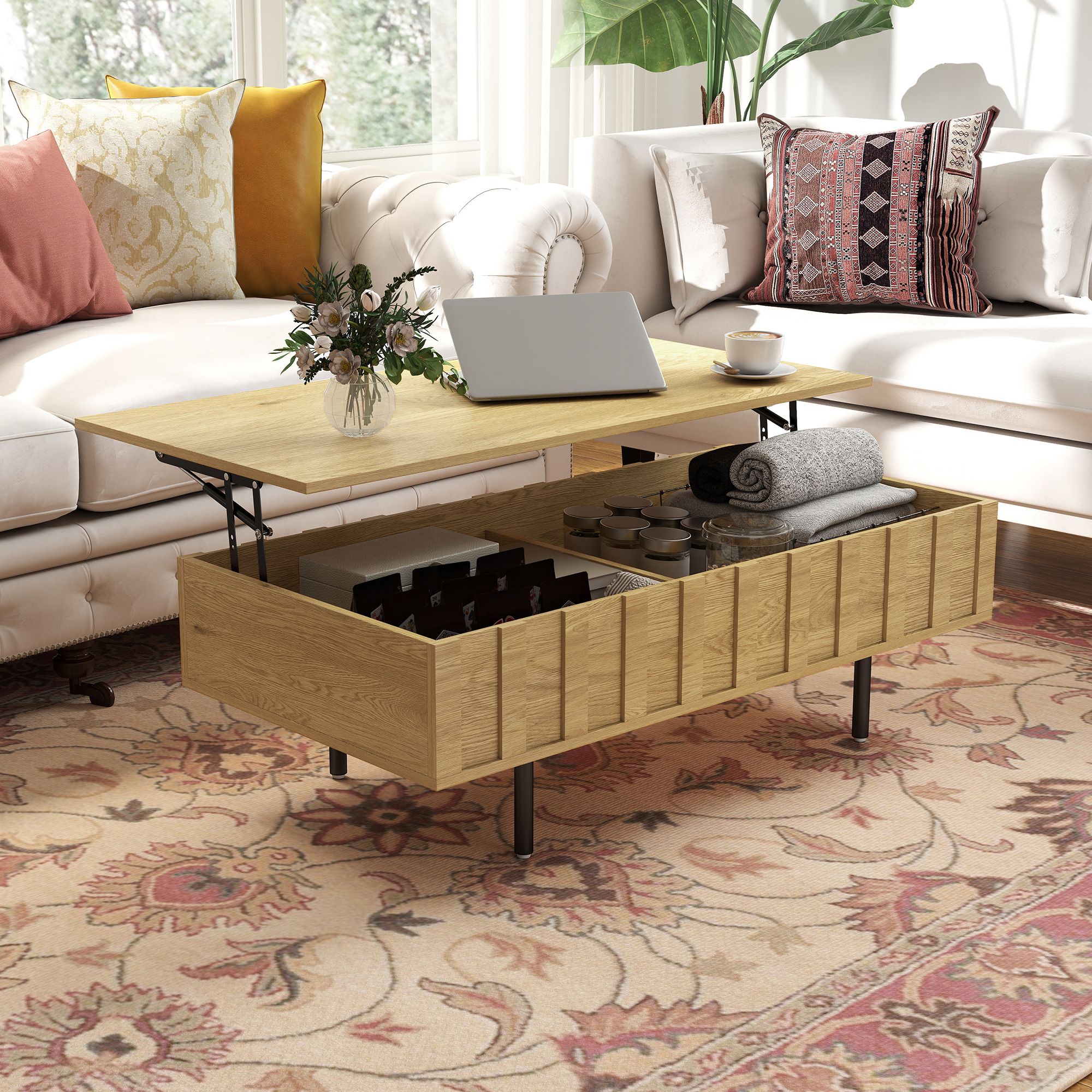 Una mesa de centro de madera elevable con almacenamiento abierto que muestra una laptop, flores y mantas dobladas.