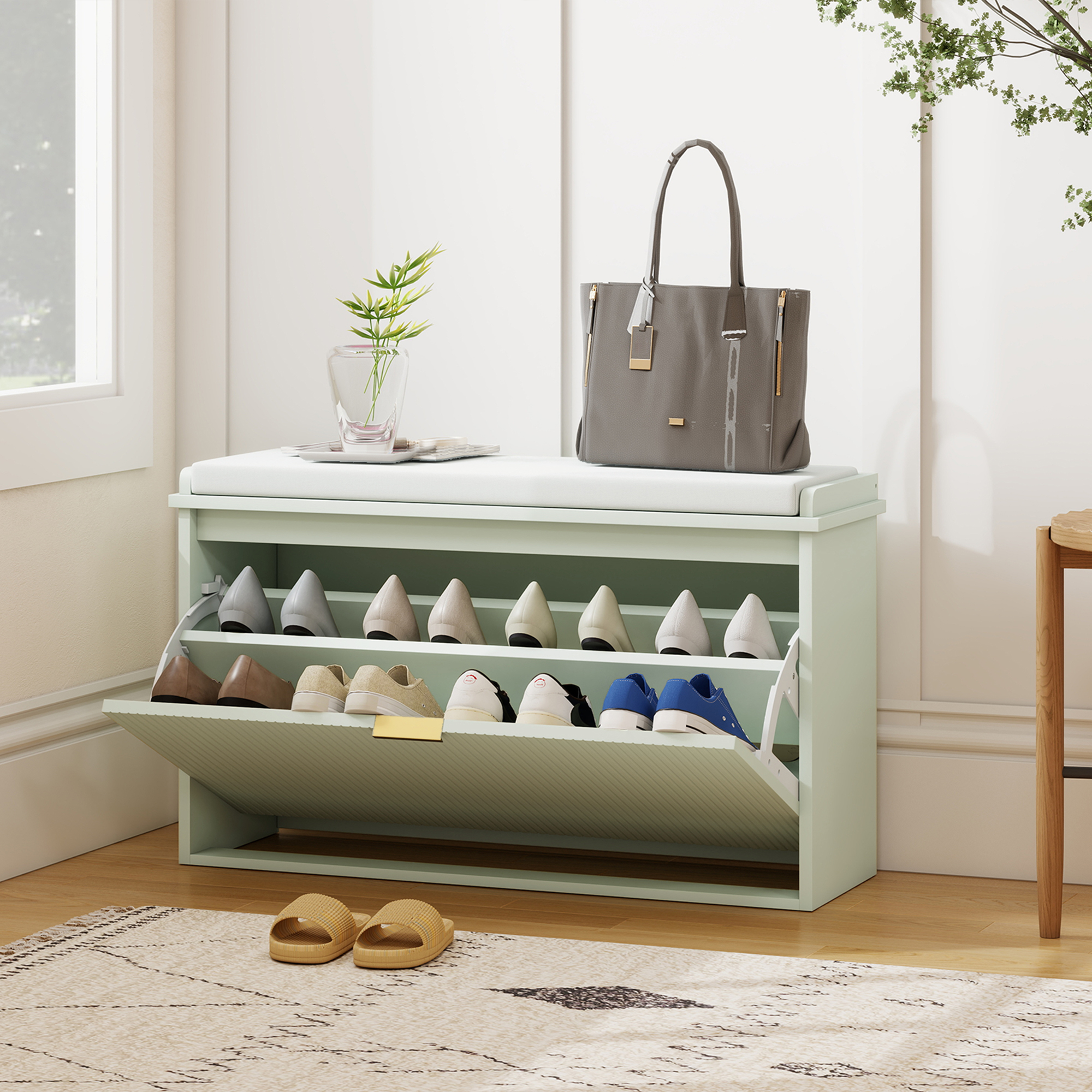 Zapatero verde con cojín, bolso gris, plantas y zapatos en el compartimento.