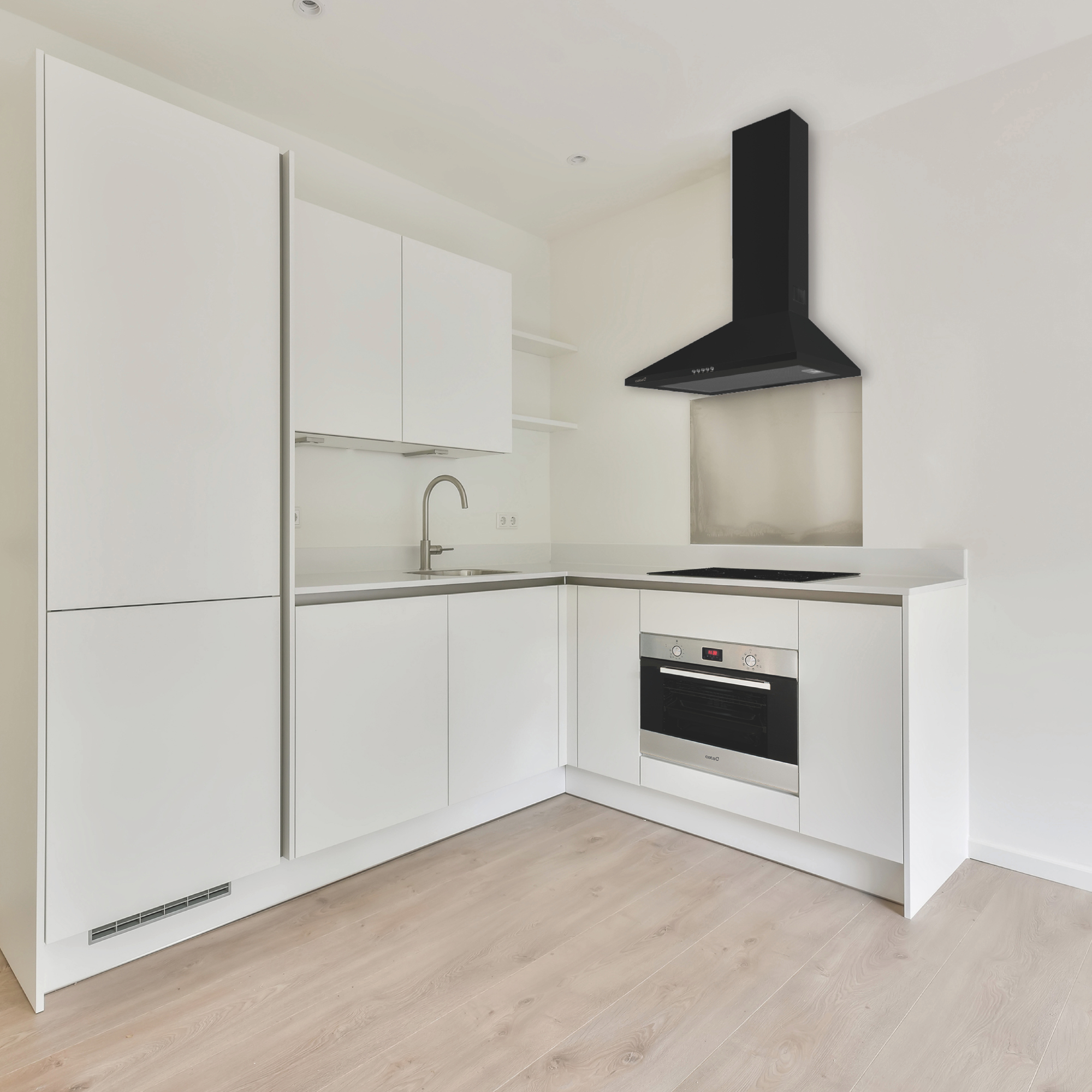 Moderna cucina bianca con cappa aspirante nera, forno in acciaio inossidabile e pavimento in legno in una stanza luminosa.