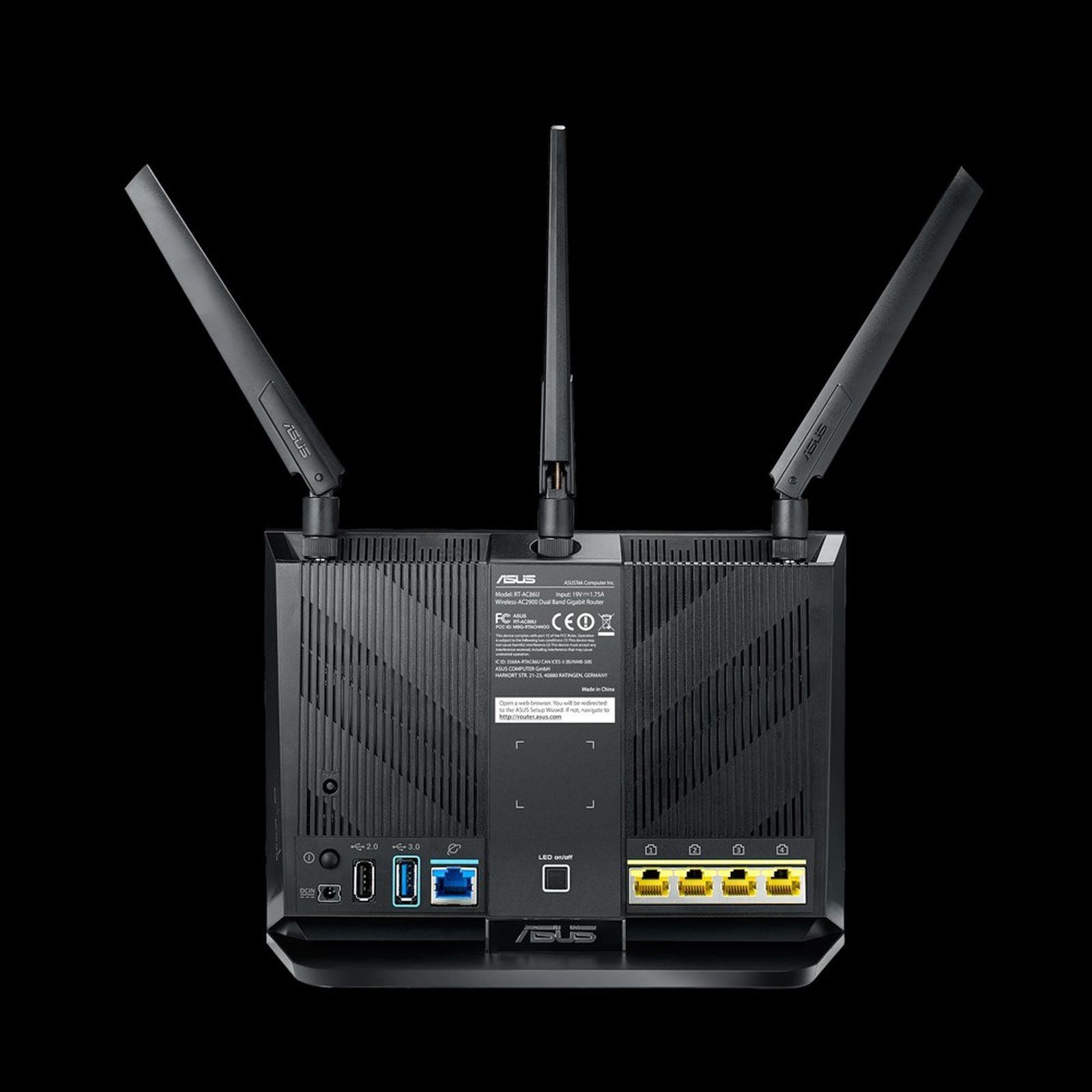 Rückseite eines schwarzen ASUS-WLAN-Routers mit drei Antennen, verschiedenen Anschlüssen und einem Aufkleber.