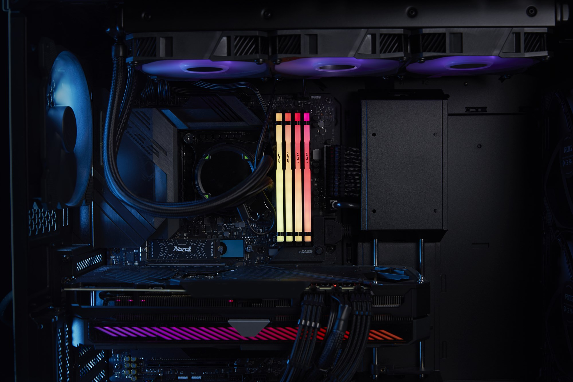 Ein PC-Innere mit leuchtenden RGB-RAM-Sticks, Kühlern und Grafikkarte in dunklem Gehäuse.