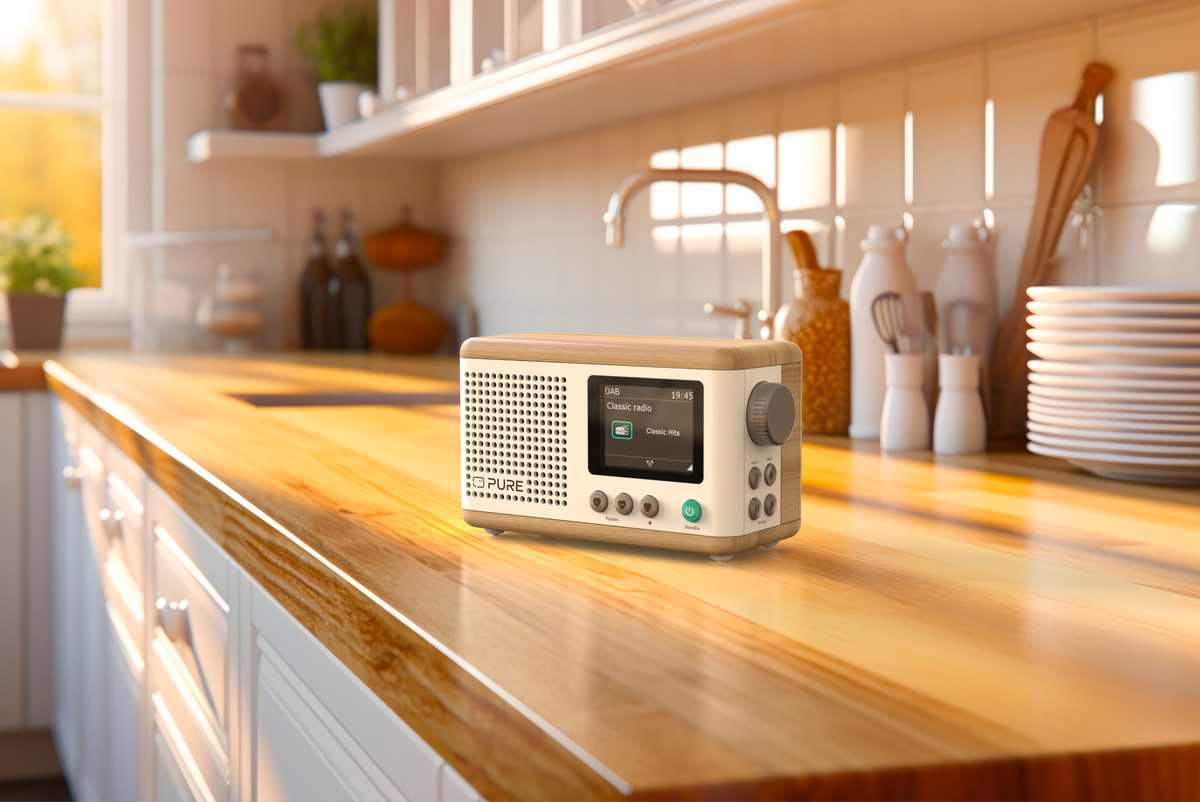 Ein weiß-braunes Pure Digitalradio auf einer hölzernen Küchenarbeitsplatte.