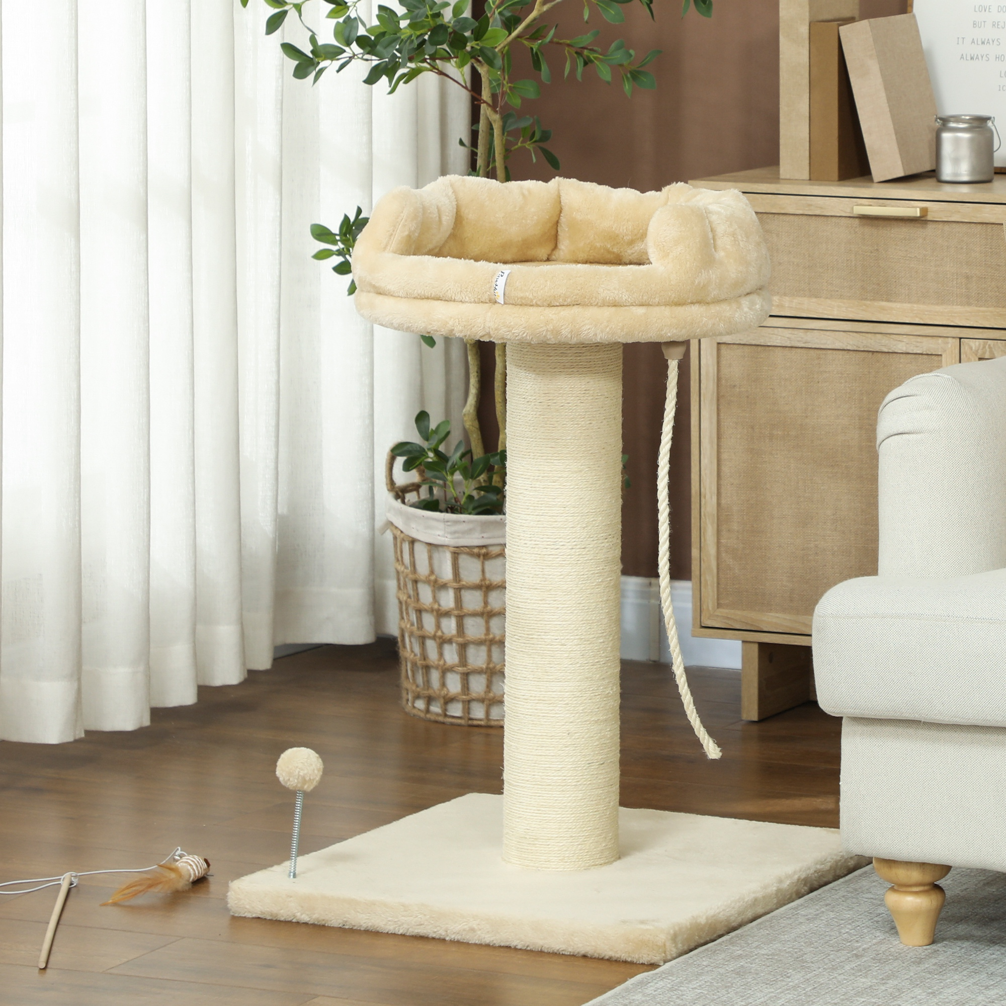 Un tiragraffi beige con cuccia morbida e corda pendente su pavimento in legno.