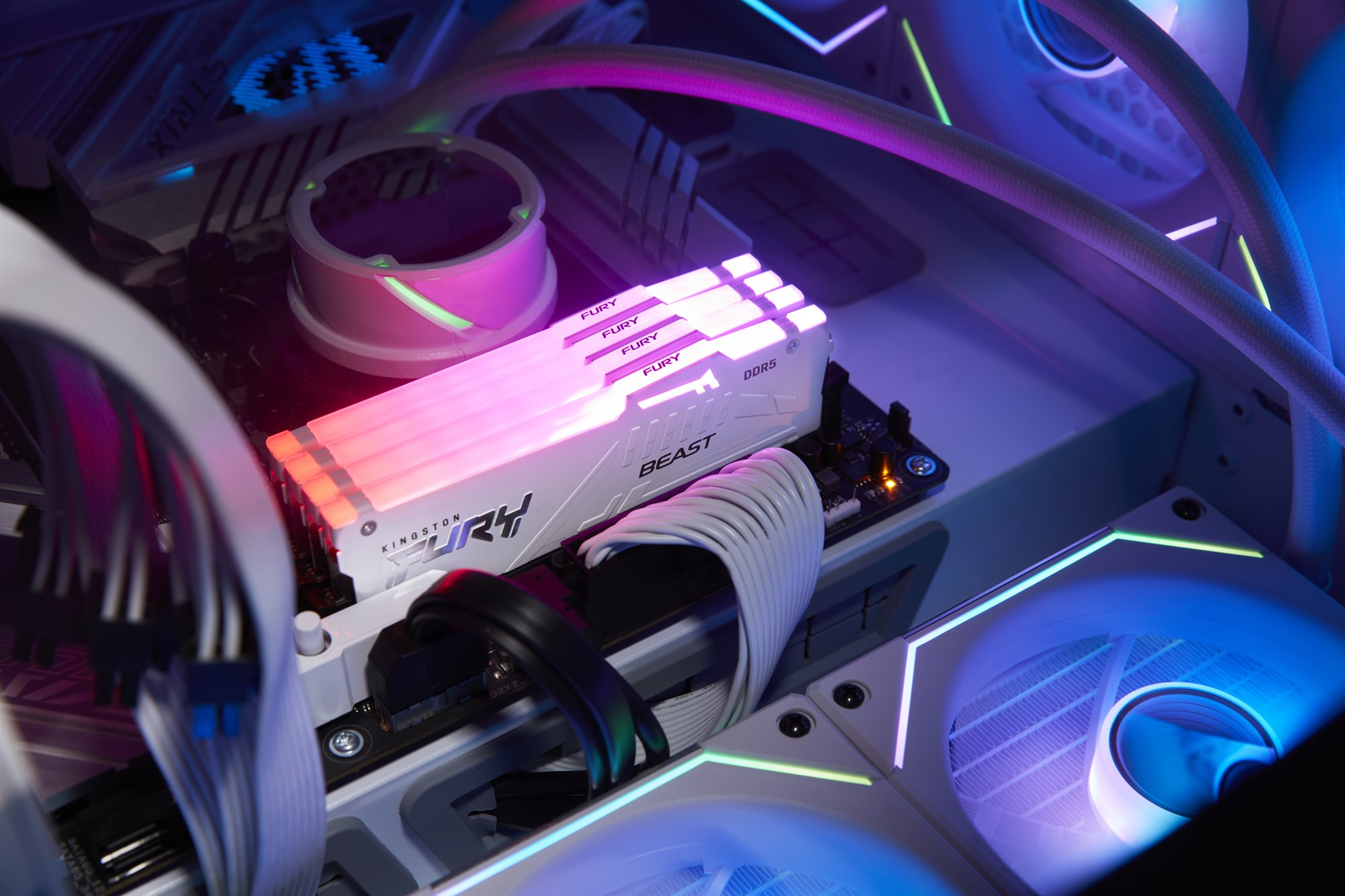 Wnętrze PC z pamięcią RAM Kingston Fury DDR5 i świecącym różowo-niebieskim oświetleniem LED.