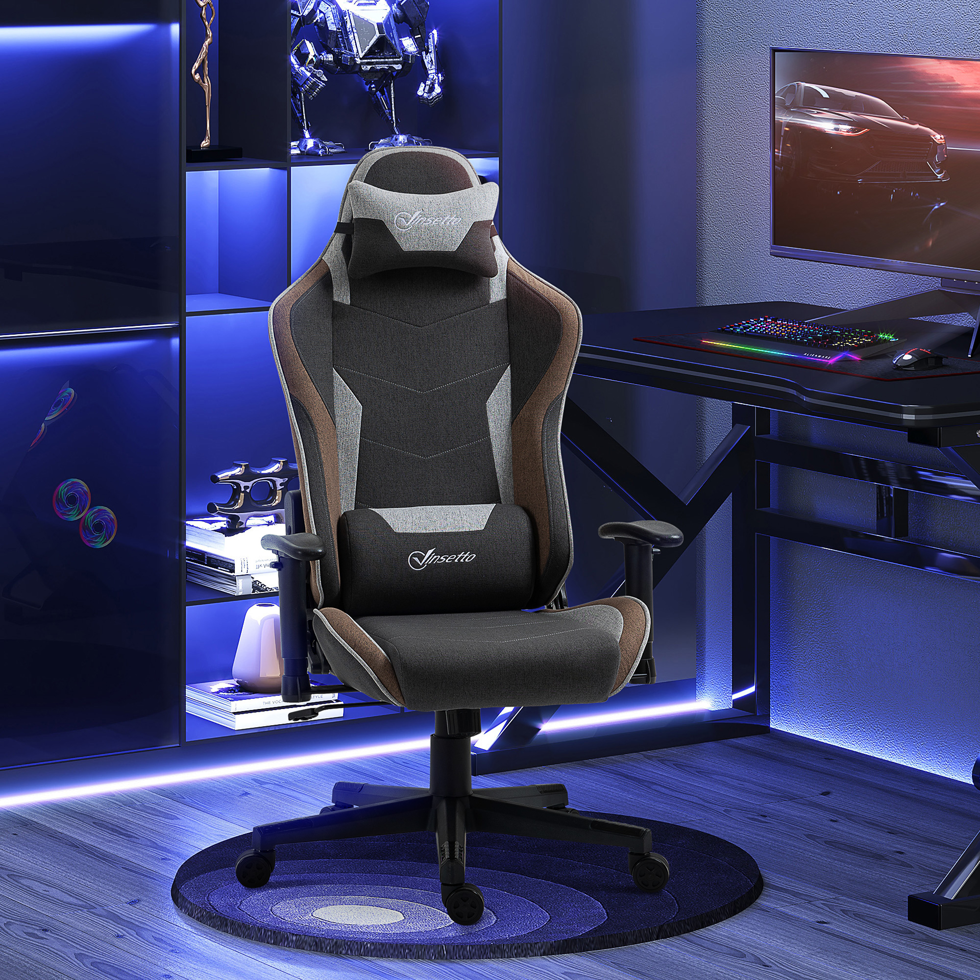 Una configurazione da gioco con una sedia ergonomica grigia e marrone davanti a una scrivania con tastiera e monitor luminosi.