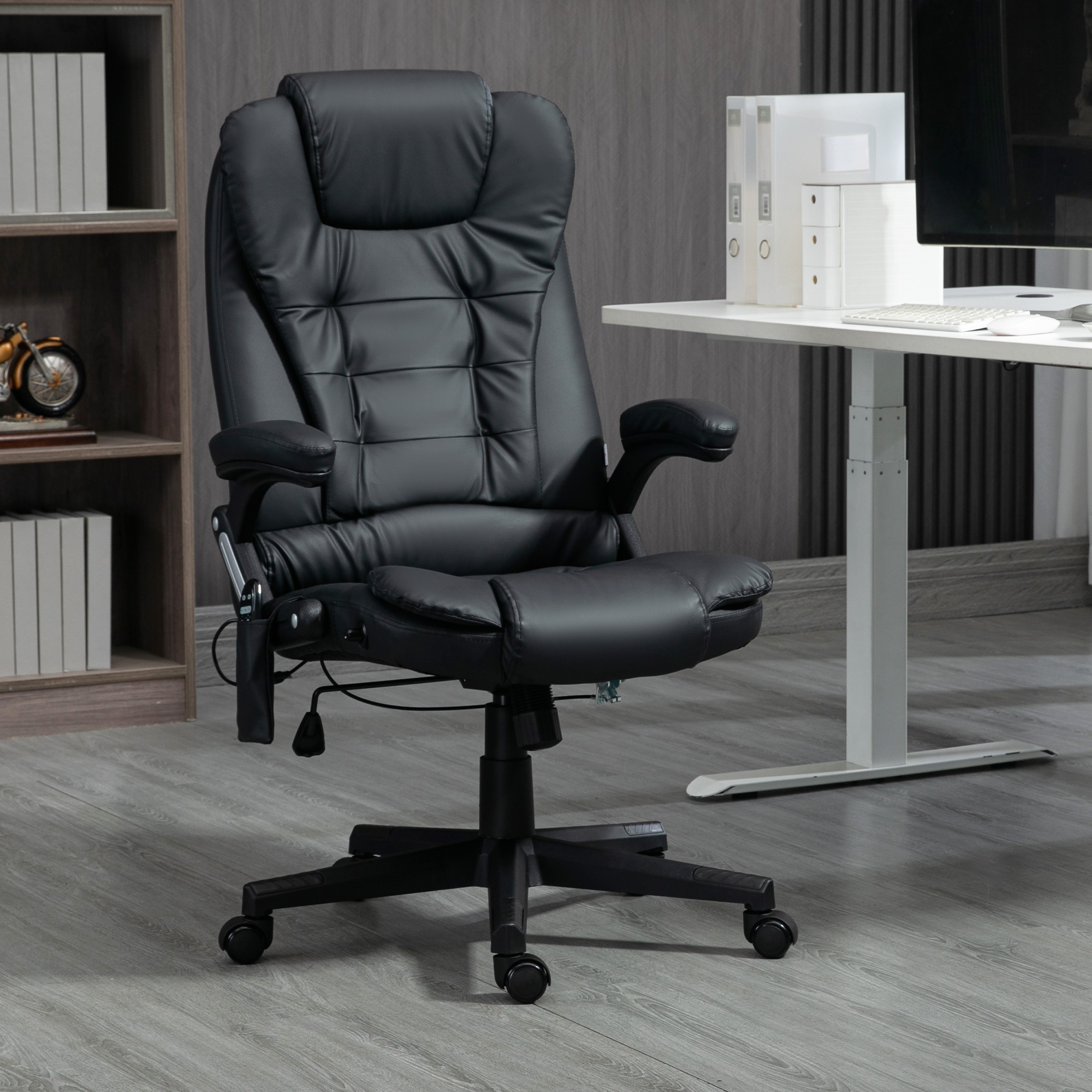 Una sedia da ufficio in pelle nera con rotelle è al centro di un ufficio con scrivania e libreria sullo sfondo.