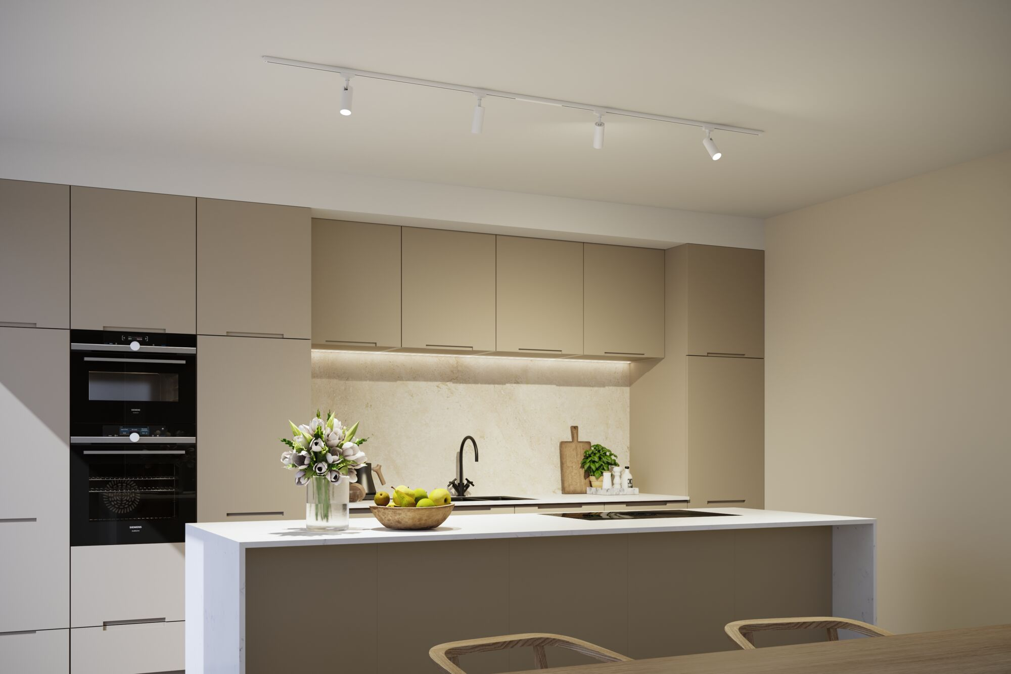 Moderne Küche in Beige mit heller Kochinsel, integrierten Öfen und Blumenstrauß.