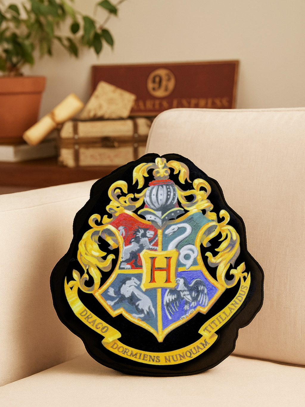 Ein Hogwarts-Wappenkissen liegt auf einem Beigesofa in einem gemütlichen Raum.