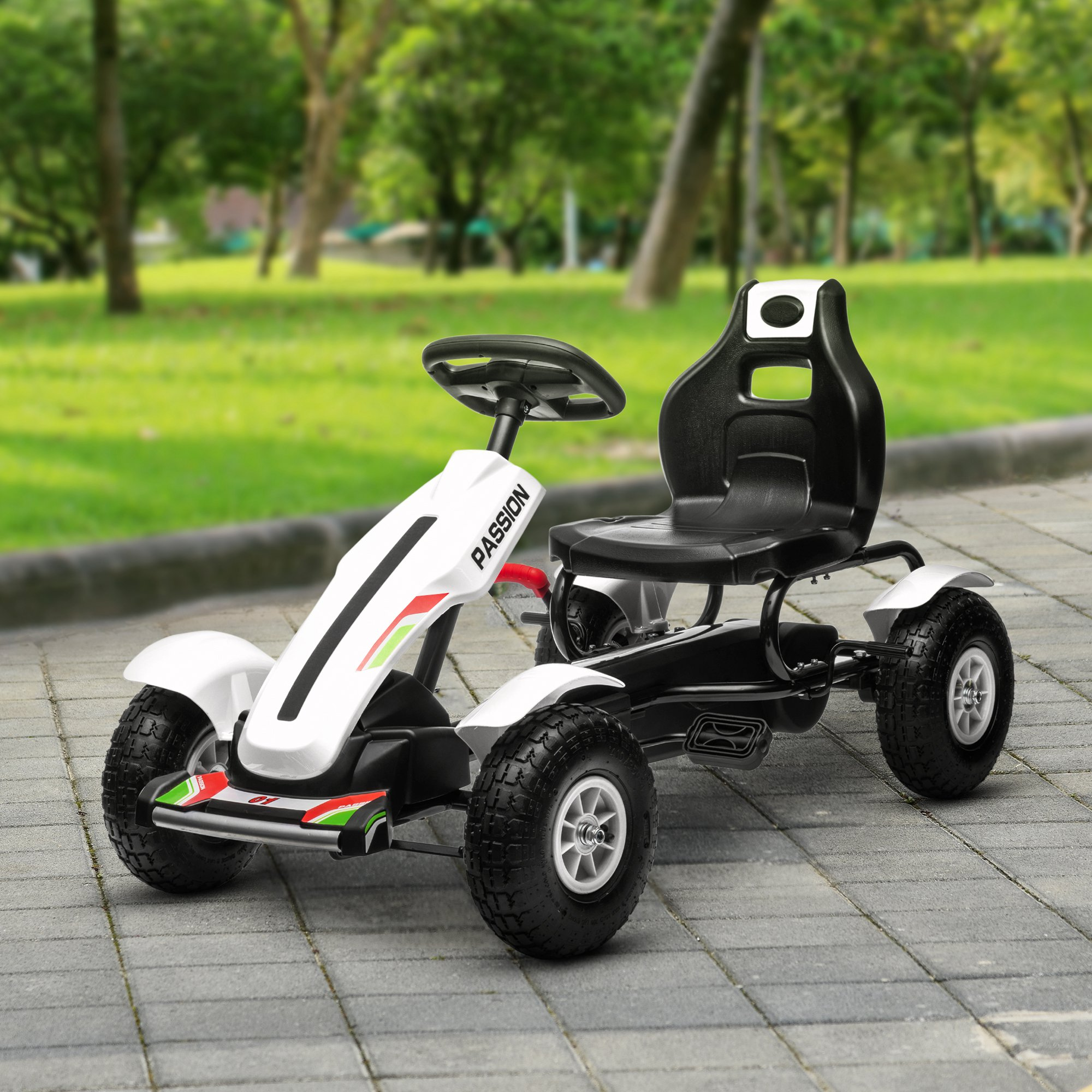 Un go-kart bianco e nero si trova su un sentiero lastricato in un parco con erba verde e alberi.