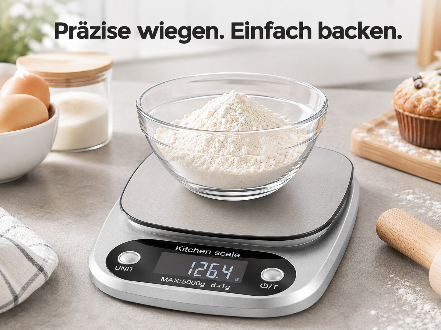 Eine silberne digitale Küchenwaage mit einer Schüssel Mehl, Eiern und einem Muffin im Hintergrund.