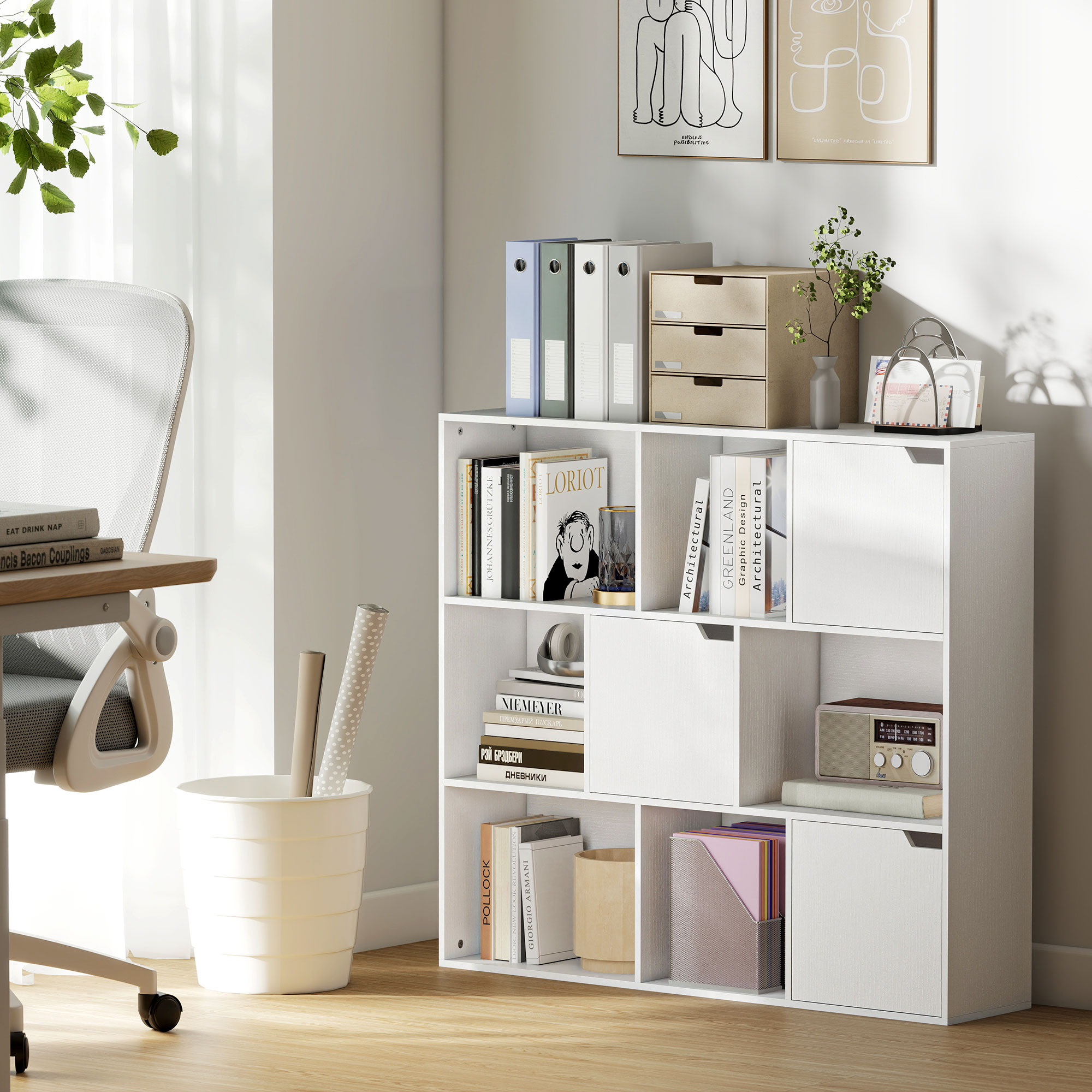 Una estantería cúbica blanca con libros, carpetas y cajones junto a un escritorio y silla.