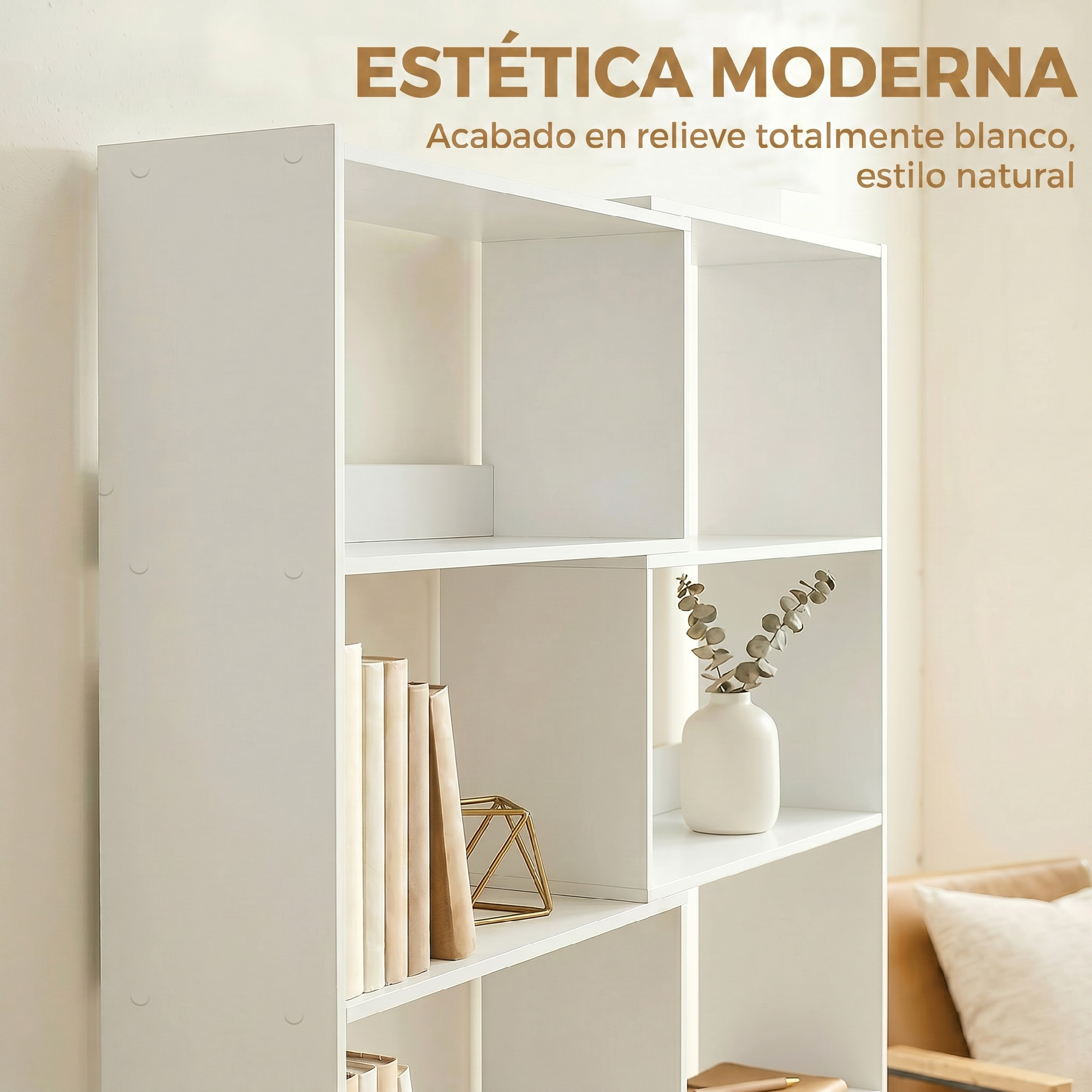 Una estantería modular blanca con elementos decorativos, libros y un jarrón con ramas en una habitación luminosa.