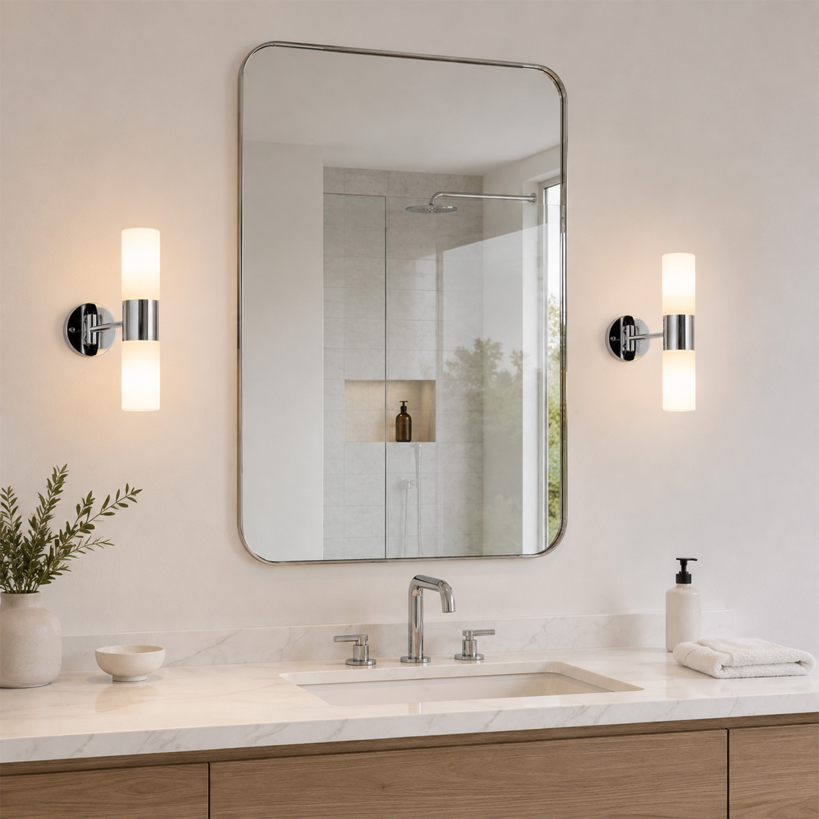 Baño con tocador de mármol, espejo iluminado y dos apliques de pared.