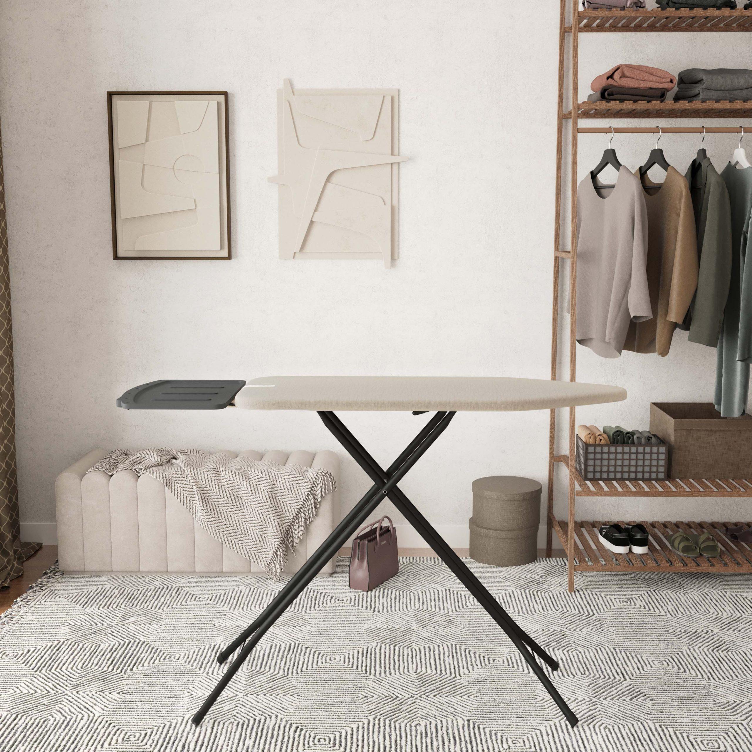 A beige and black ironing board stands on a patterned rug before a white wall.