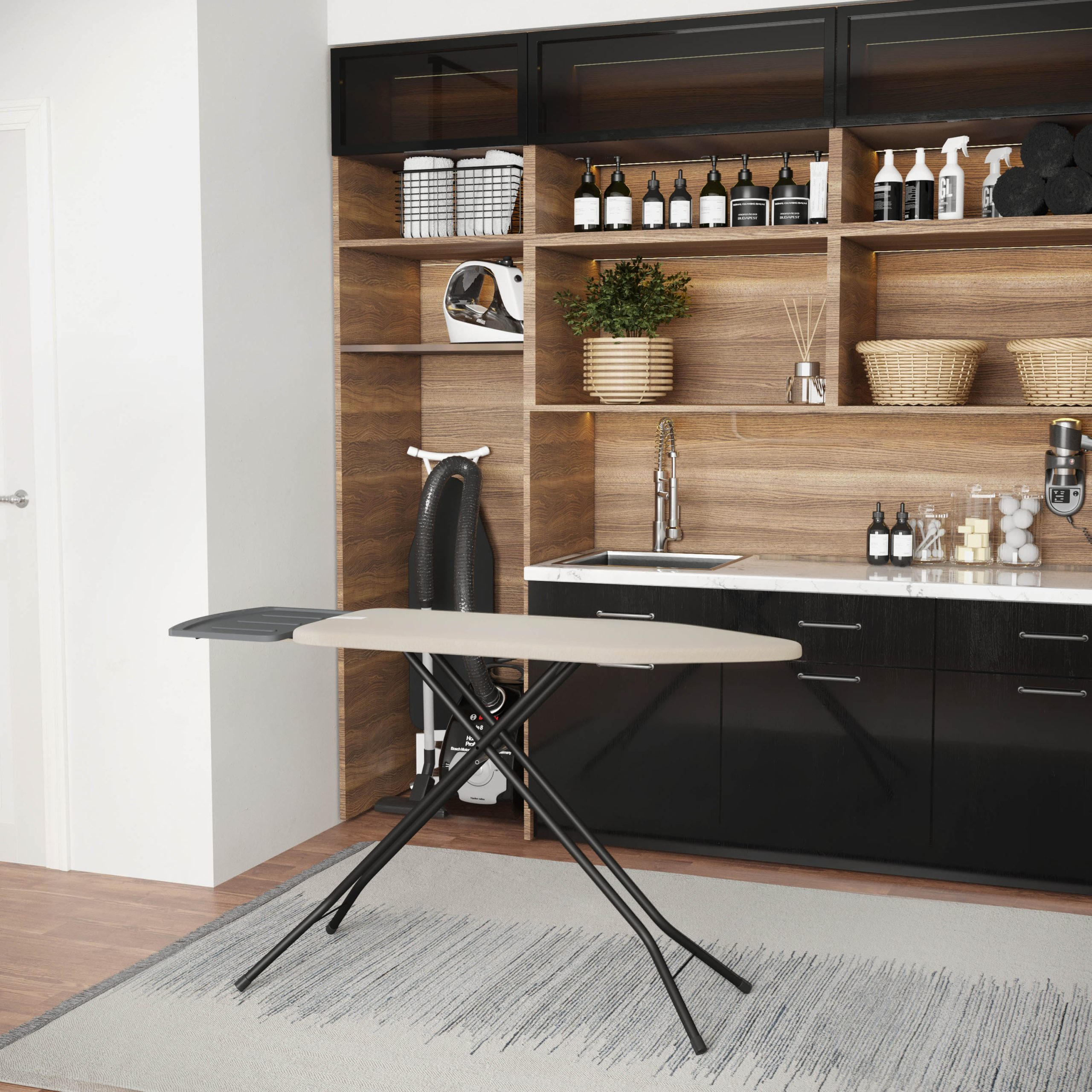 An ironing board stands on a patterned rug in front of a modern laundry room with wooden shelves and black cabinets.