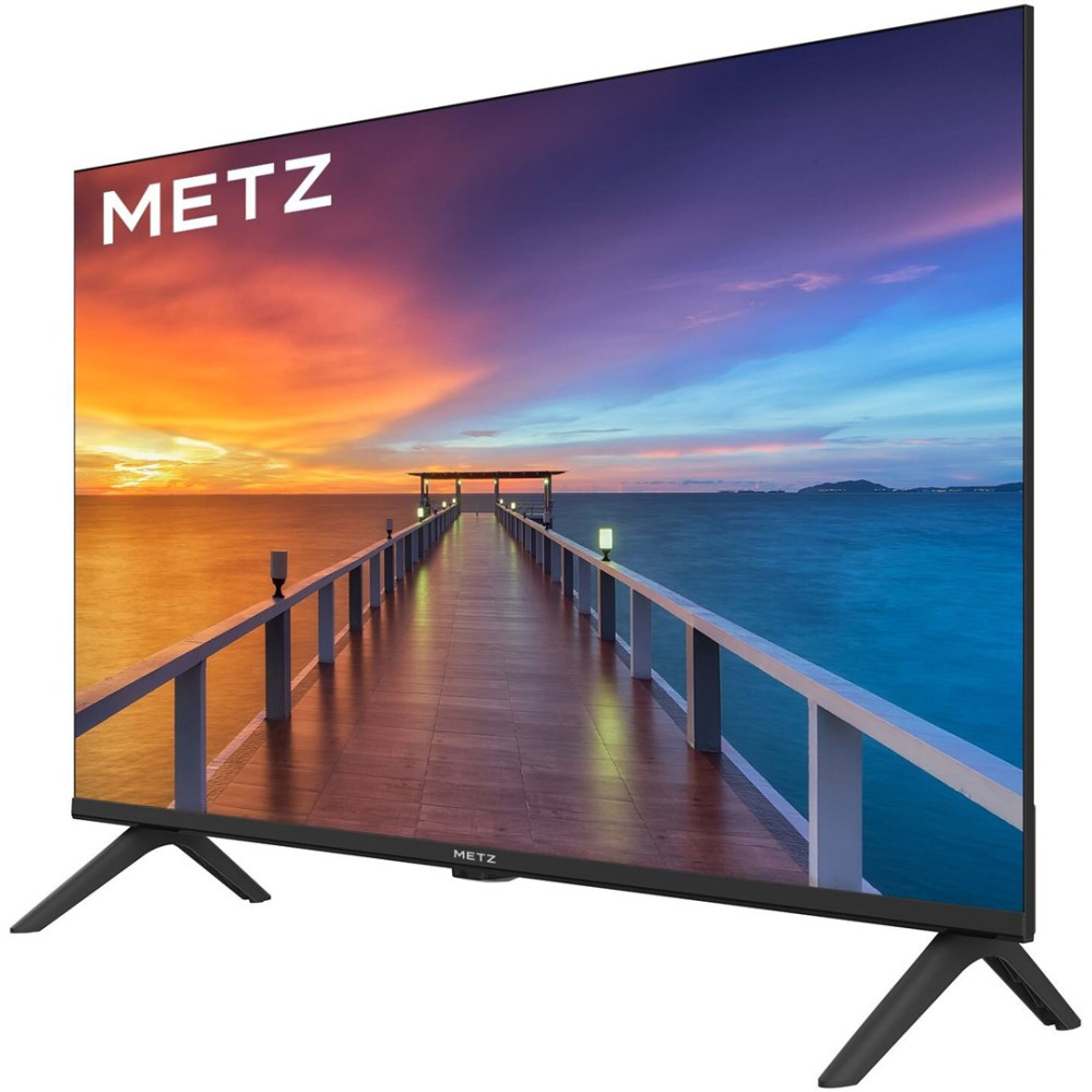 Telewizor Metz na czarnych podstawach wyświetla malowniczy drewniany pomost nad oceanem podczas kolorowego zachodu słońca.