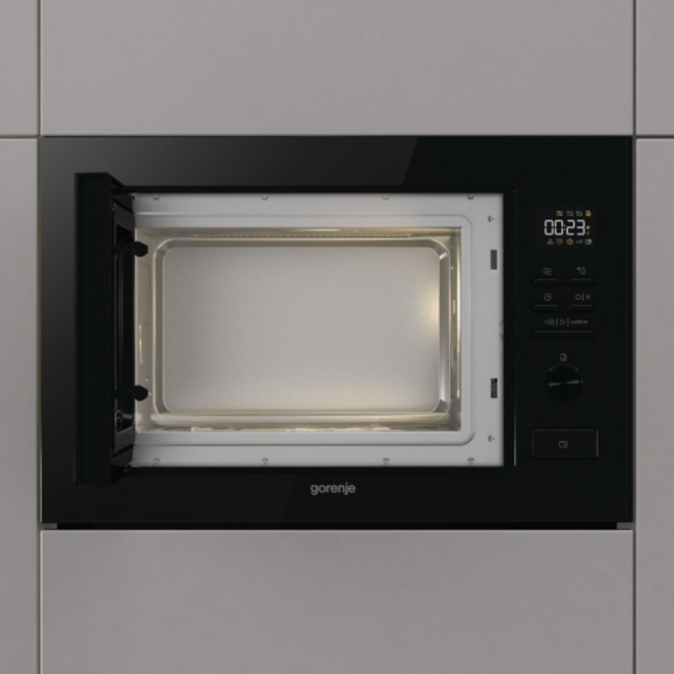 Wbudowana czarna kuchenka mikrofalowa Gorenje z otwartymi drzwiami i cyfrowym wyświetlaczem.