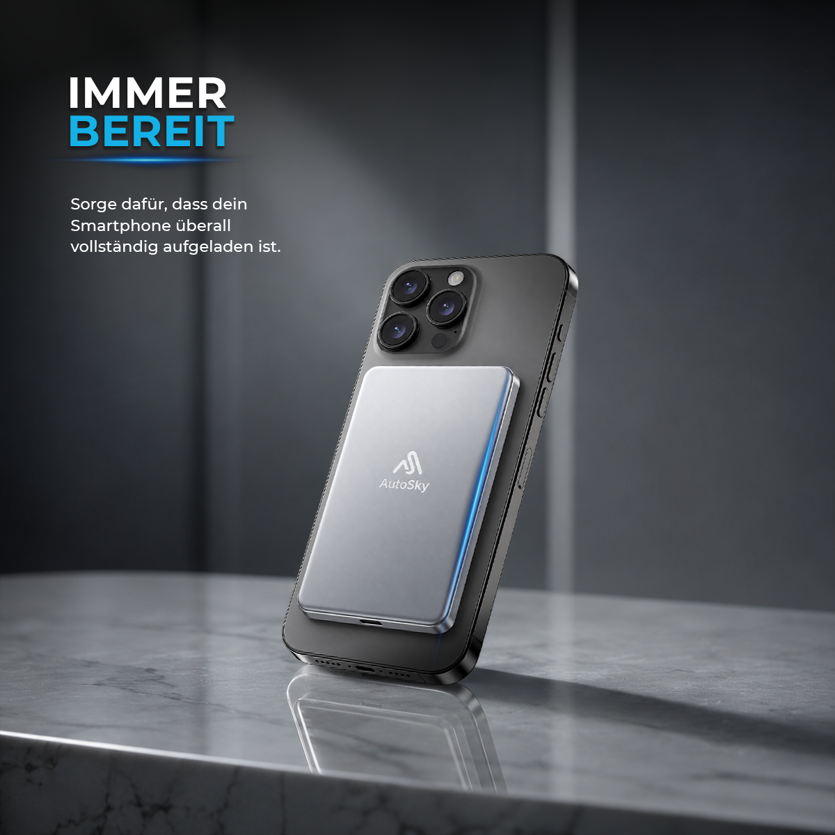 Ein graues Smartphone steht auf einem Tisch mit einer silbernen AutoSky Powerbank auf der Rückseite.