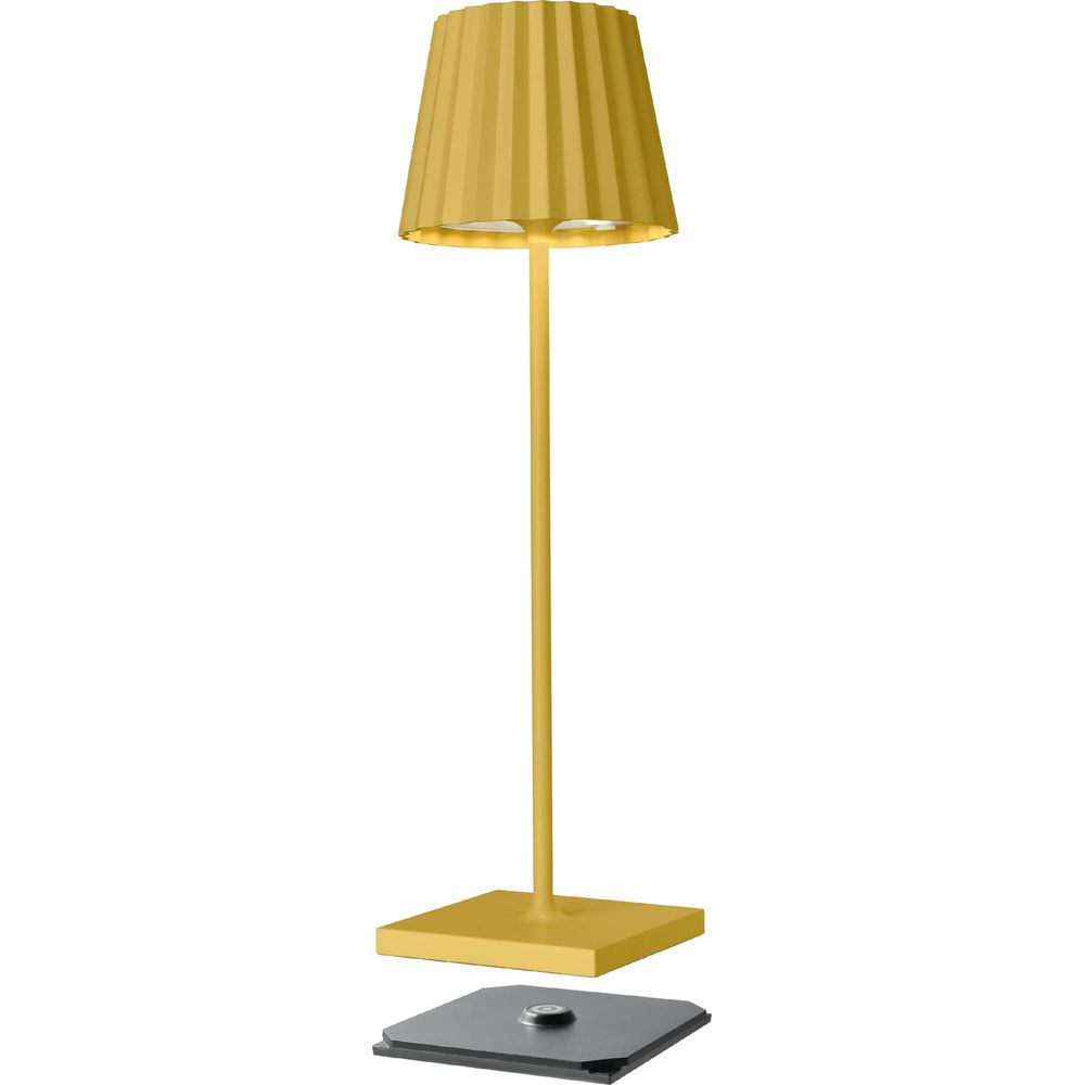 Une lampe de table jaune avec un pied fin et un abat-jour plissé flotte au-dessus d'une base noire sur fond blanc.