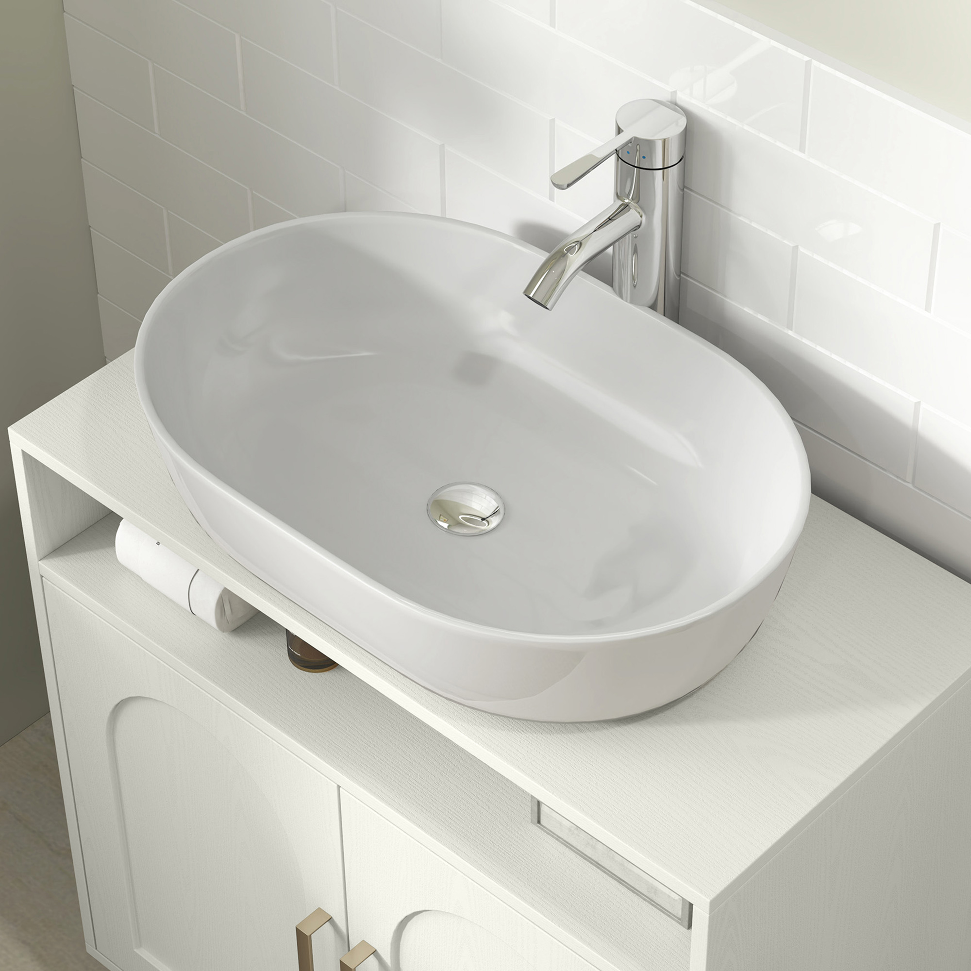 Un lavabo ovalado blanco con grifo cromado sobre un mueble blanco frente a azulejos blancos.