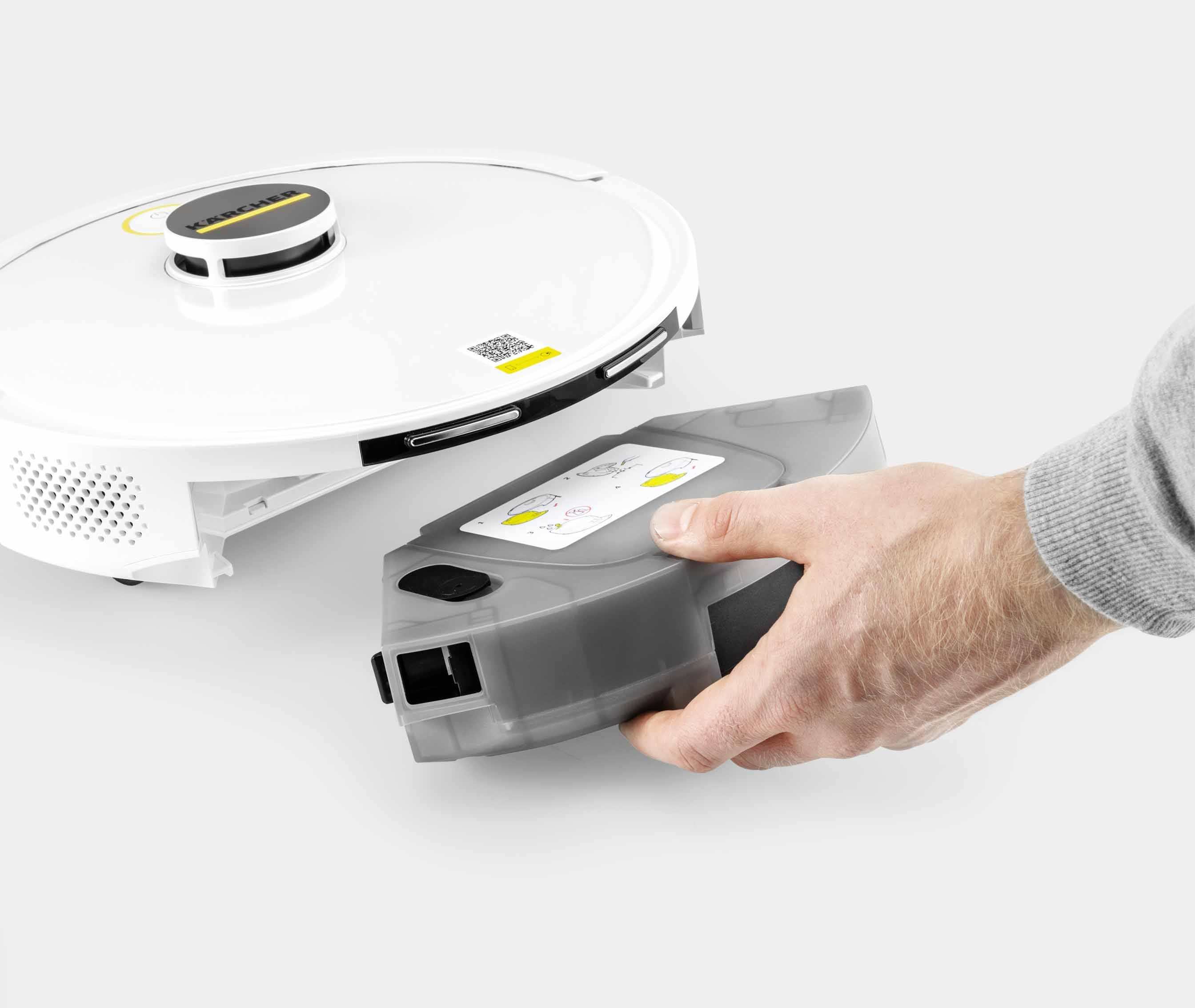 A hand removing the water tank from a white robotic vacuum cleaner.