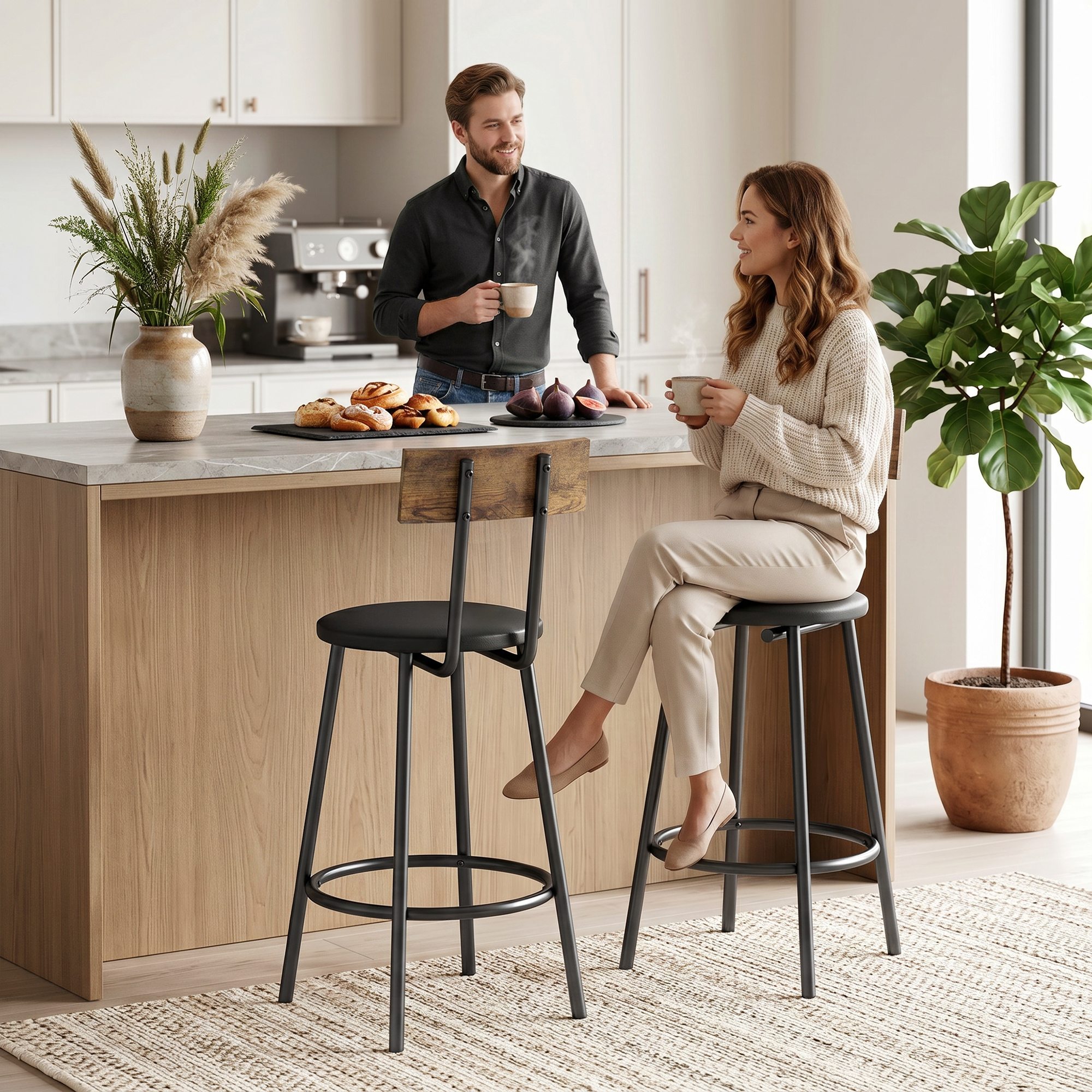 Un hombre y una mujer beben café en una cocina moderna con una isla de madera y taburetes.