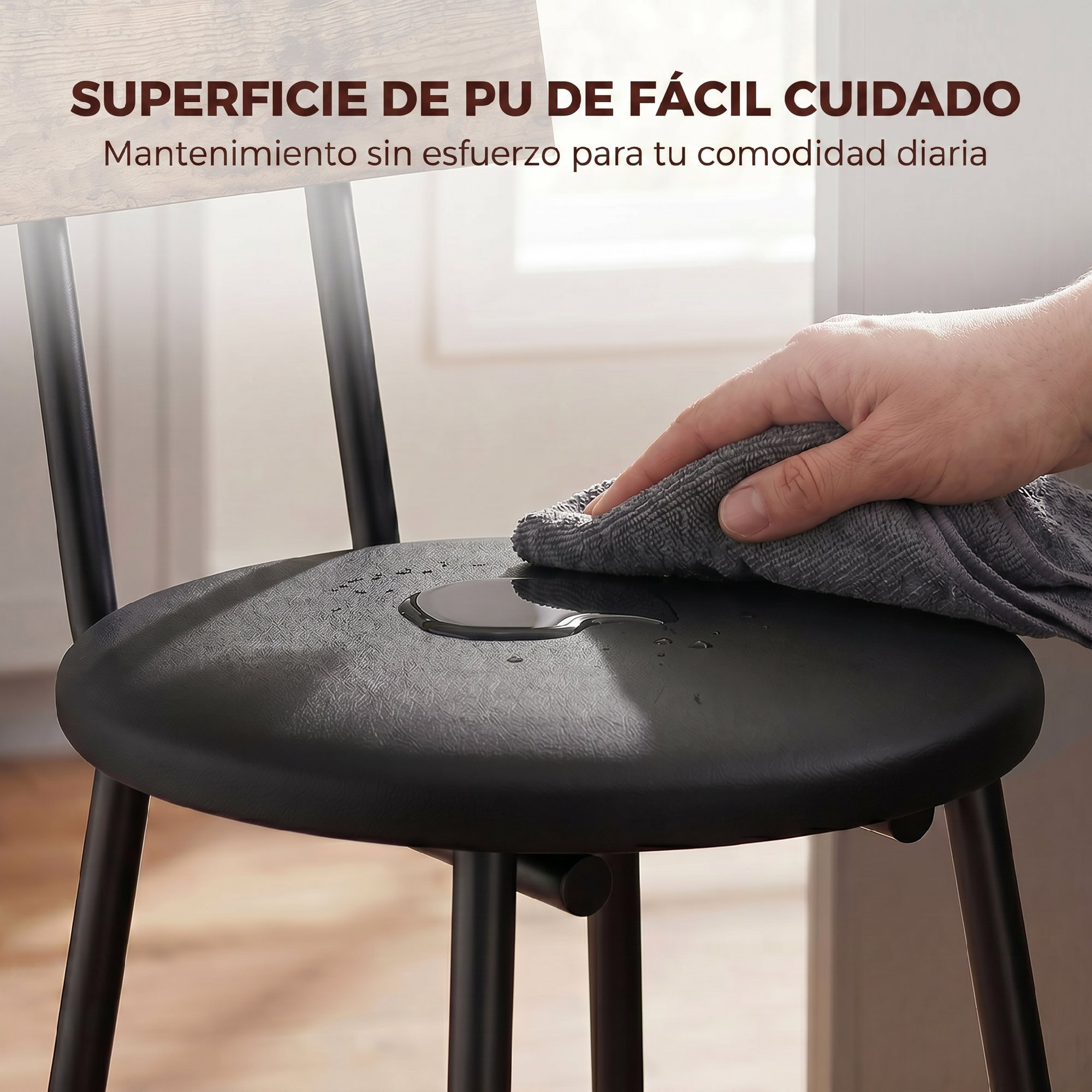 Una mano limpia agua del asiento negro de PU de una silla con un paño gris.
