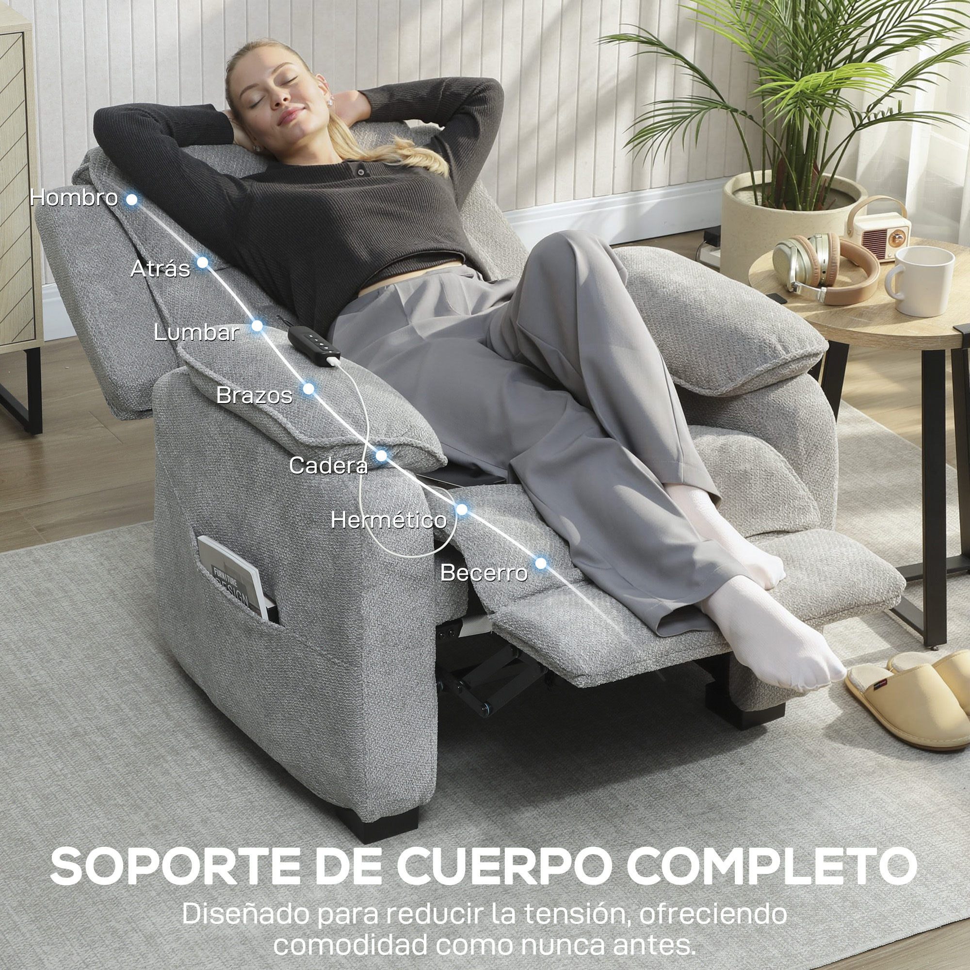 Una mujer se relaja en un sillón de masaje gris con puntos de función, junto a una mesa con auriculares.