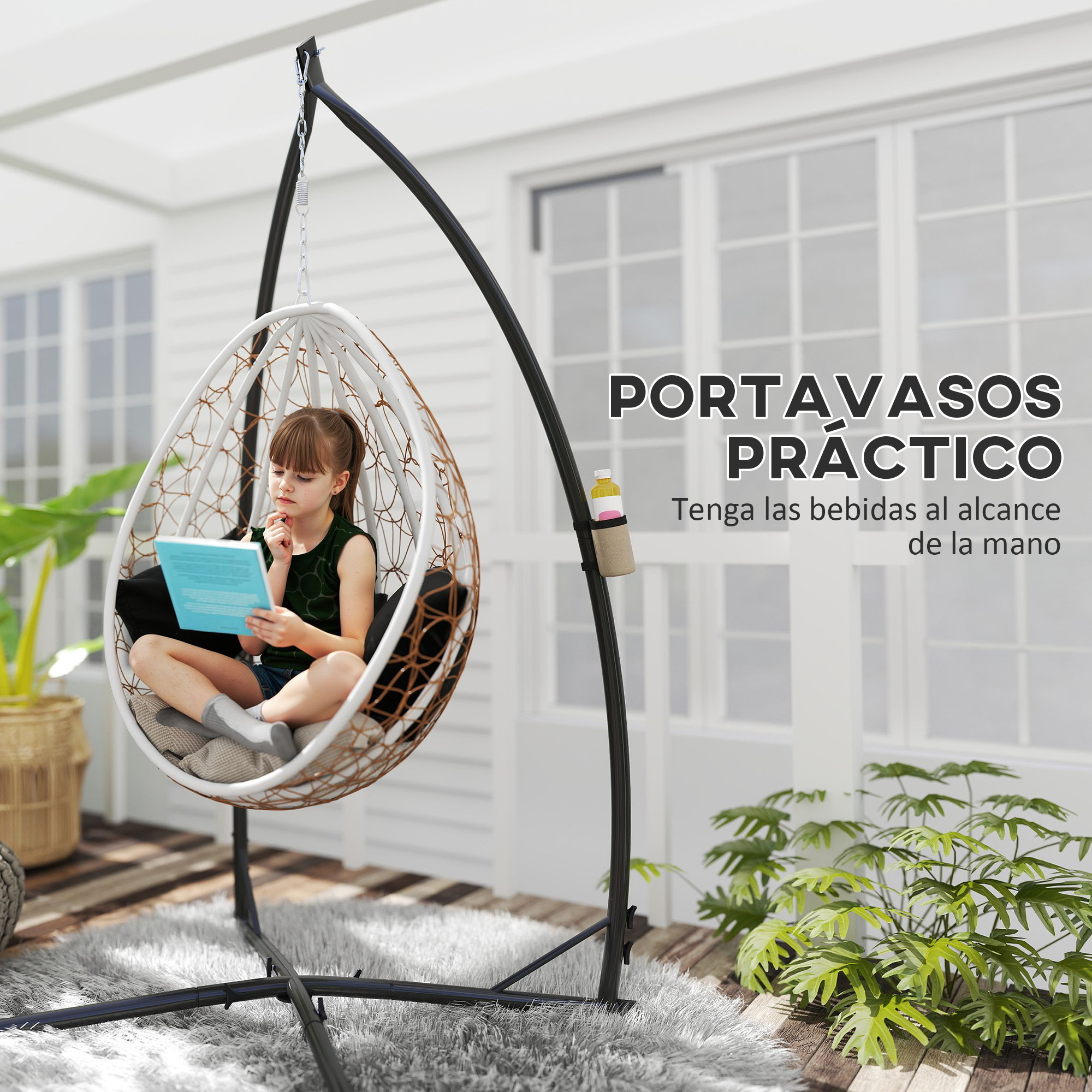 Una niña se sienta en una silla colgante blanca en una terraza, leyendo un libro azul.
