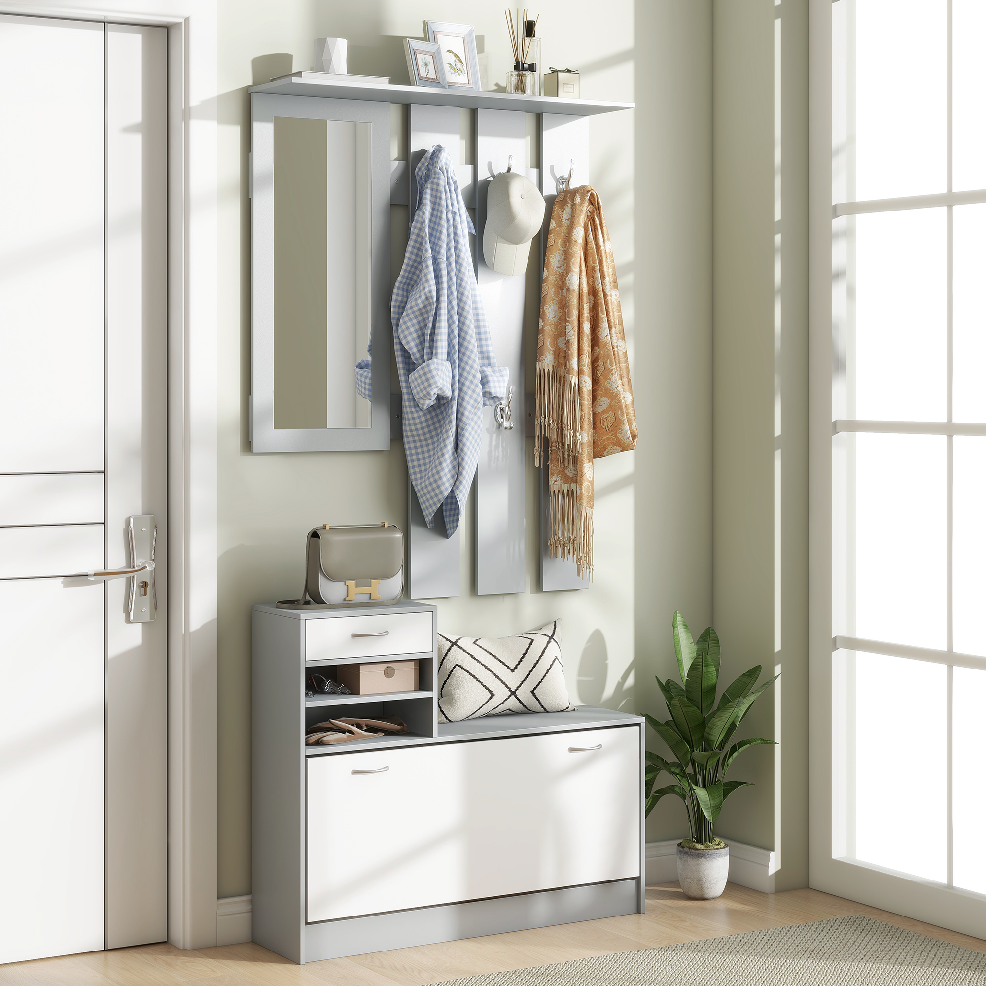 Mueble de recibidor gris y blanco con espejo, sombrero, chaqueta, bufanda, bolso y cojín en un pasillo.